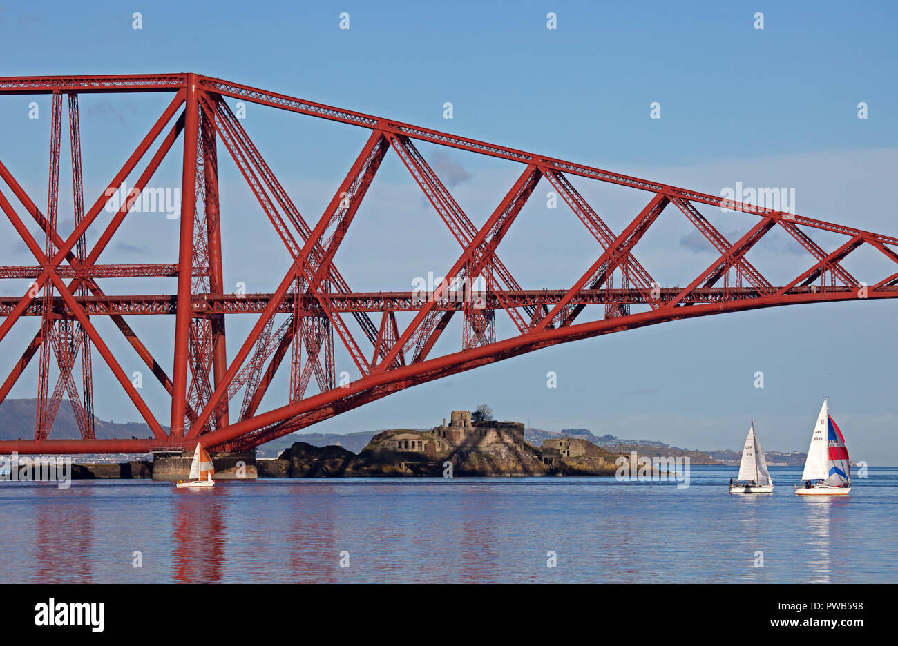 Edinburgh, UK. 14 October 2018. UK weather, after a very cloudy cold morning the sun appeared in early afternoon and at 13 degrees it felt warm in the sunshine, not much wind to assist the crews of the small sail boats in the Forth estuary under the Forth Rail Bridge. Stock Photo