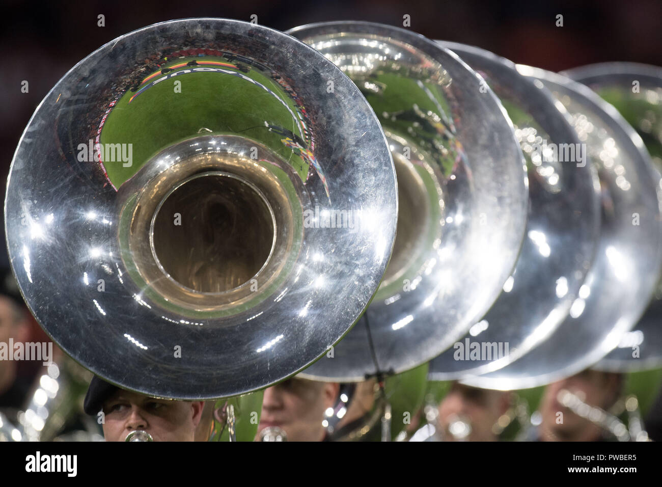 In the tuba, the playing field is reflected, musicians with tuba on the