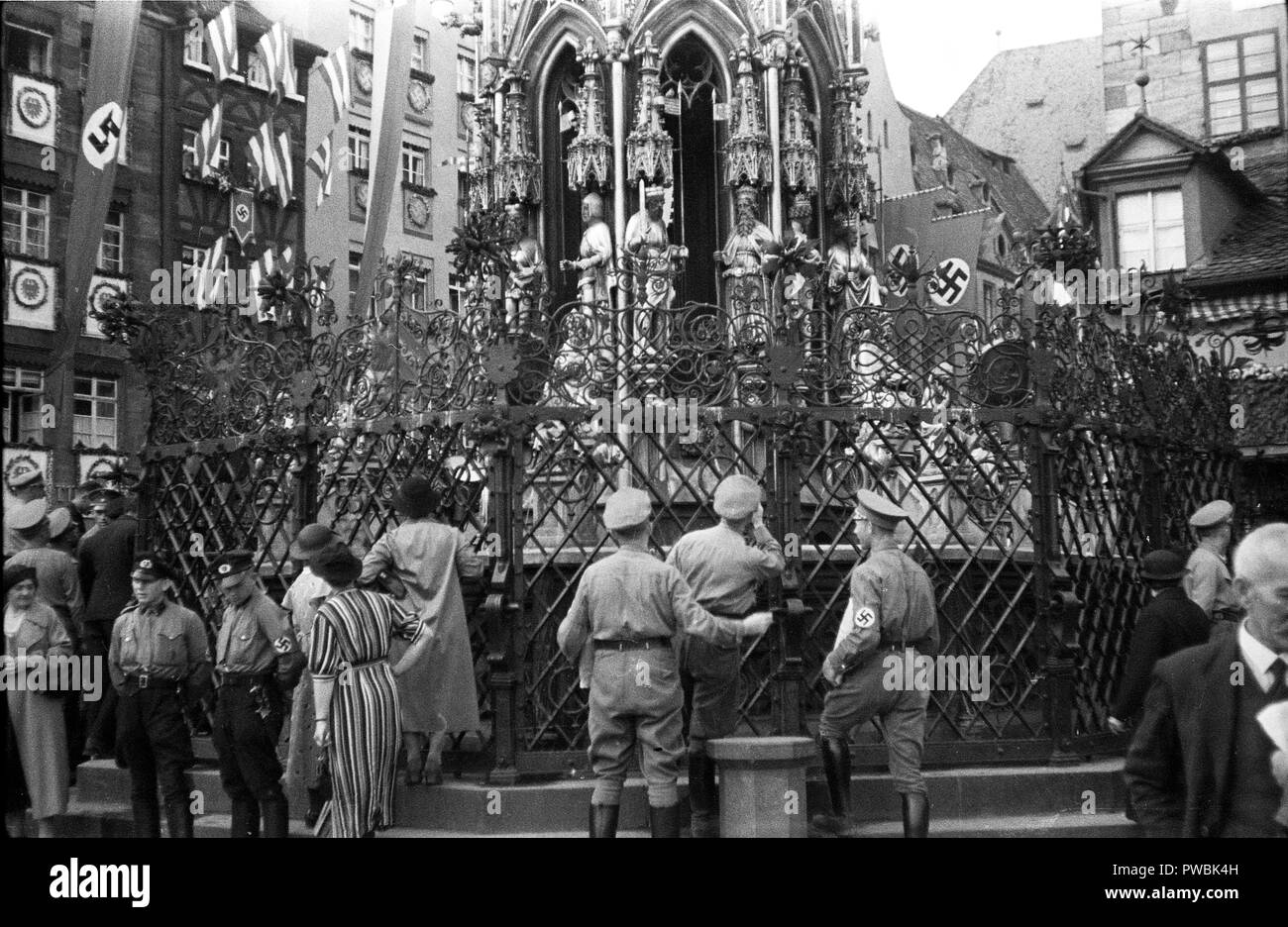 Germans  around the Schoene Brunnen or Beautiful Fountain in Hauptmarkt Square. Nuremberg, Bavaria, Germany for the Nazi Germany NSDAP Nuremberg Rally 1936 Parade at the rally ground 10th September 1936 Stock Photo