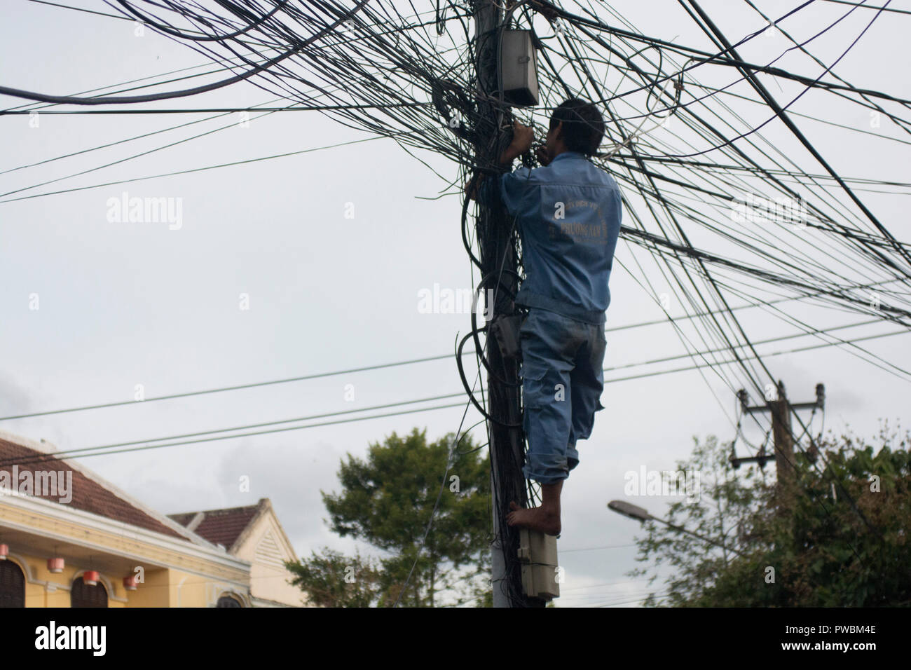 Electric worker fixing electricity mess, Da Lat, Vietnam Stock Photo