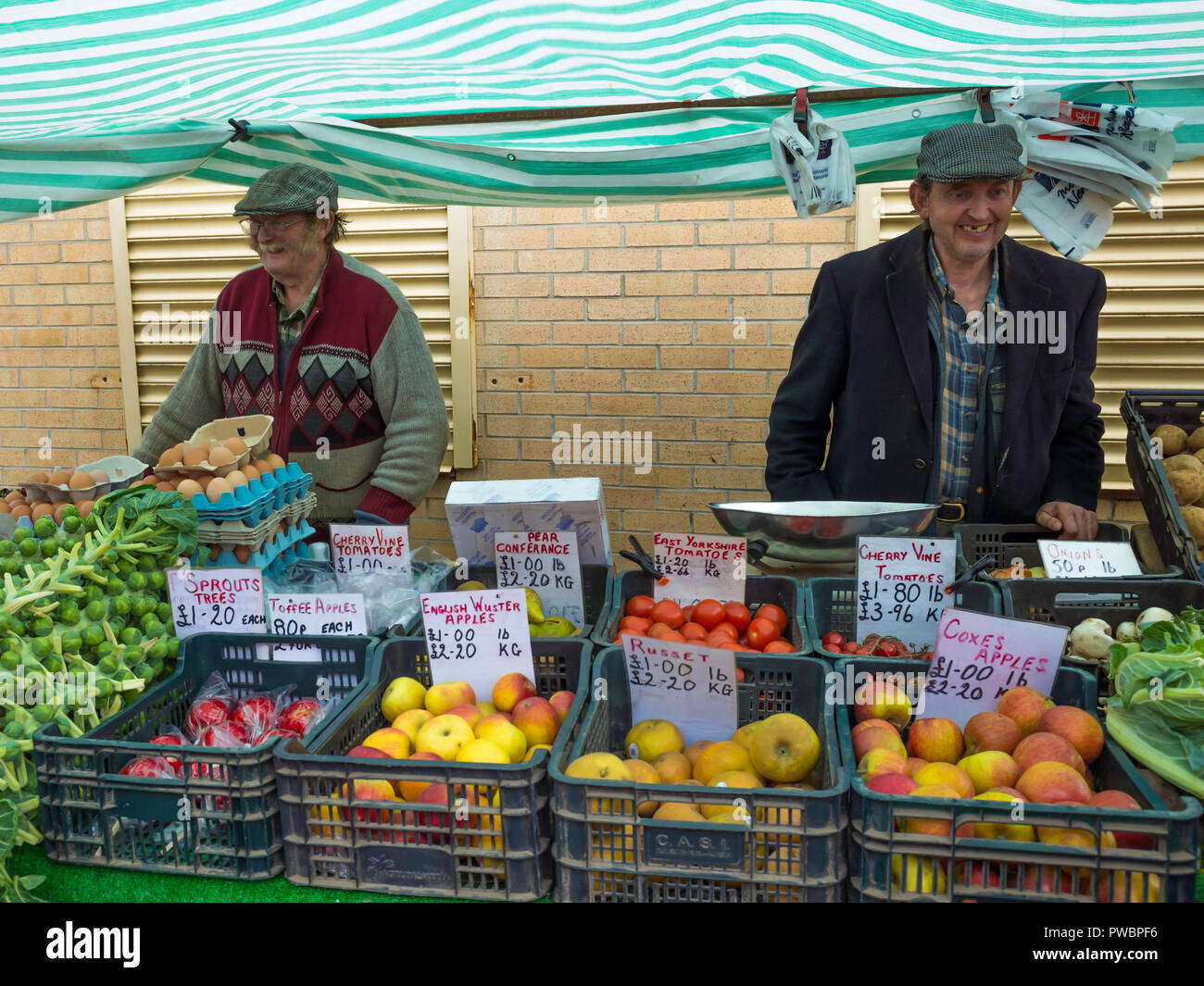 Two smiling North Yorkshire Farmers displaying their vegetables and farm produce at a Farmers Market sale in North Yorkshire Stock Photo