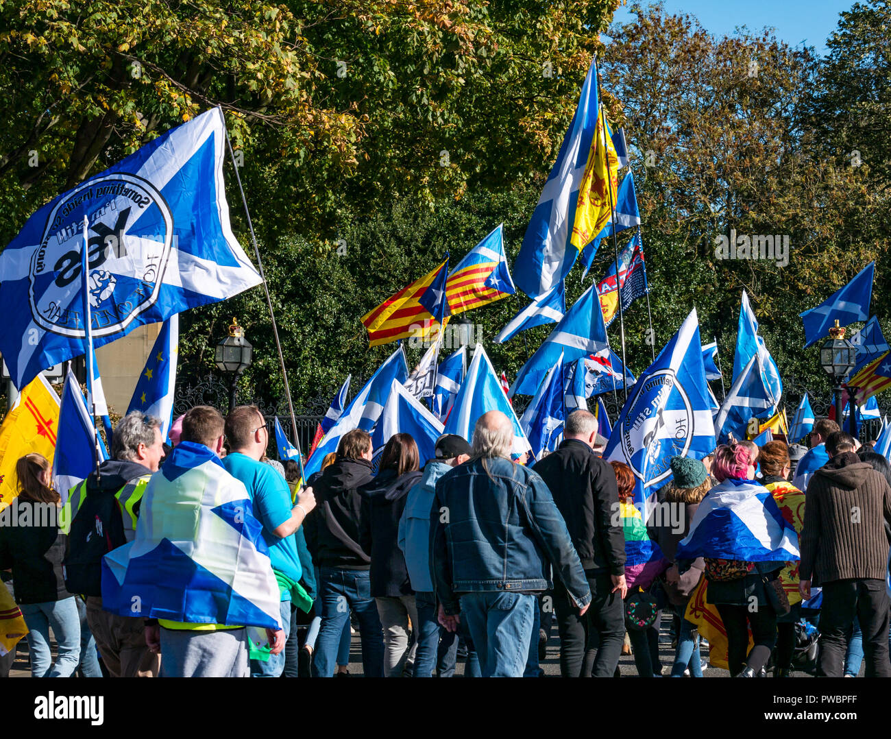 People waving saltire Scottish national flags marching at All Under One Banner Scottish Independence march 2018, Royal Mile, Edinburgh, Scotland, UK Stock Photo