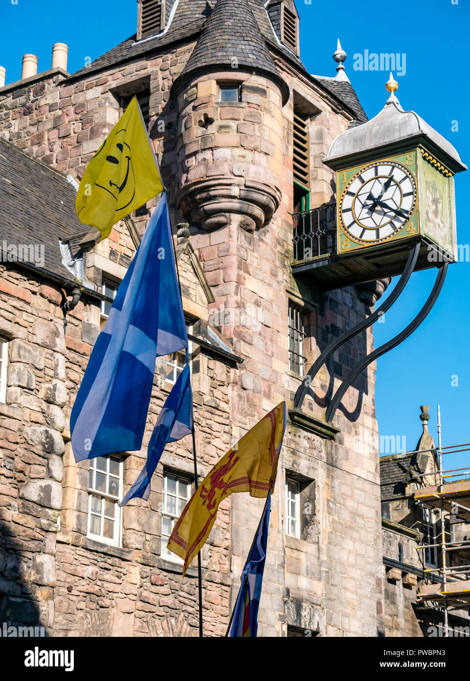 Tolbooth clock with St Andrew's Cross saltire Scottish national flags at All Under One Banner Independence march, Royal Mile, Edinburgh, Scotland, UK Stock Photo