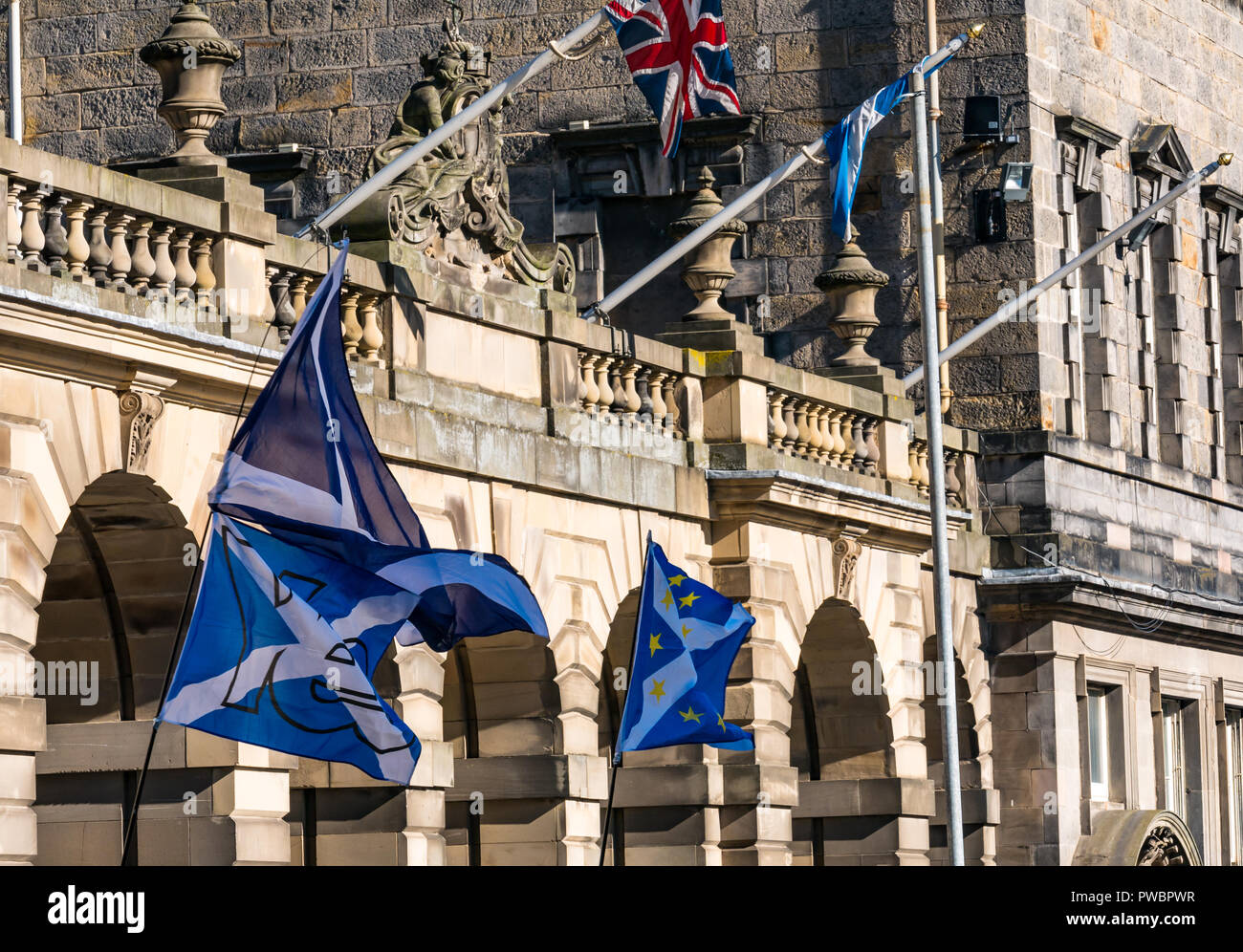 Saltire flags waving at All Under One Banner Scottish Independence march 2018, City Chambers, Royal Mile, Edinburgh, Scotland, UK Stock Photo