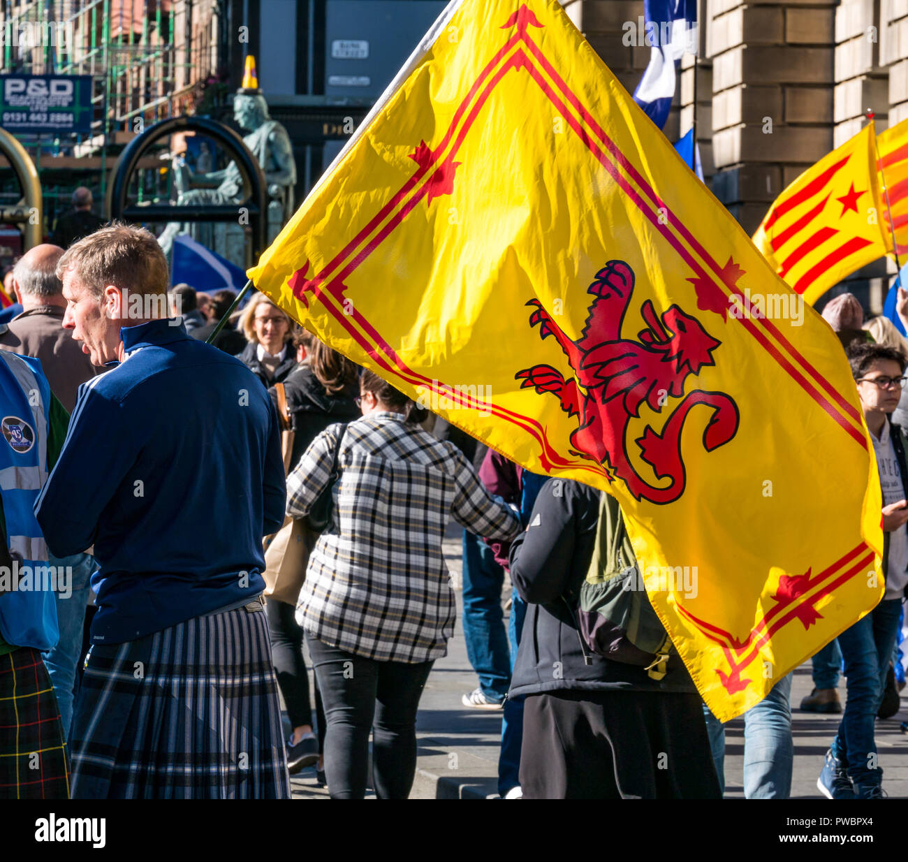 People waving national flags joining All Under One Banner AUOB Scottish Independence march 2018, Royal Mile, Edinburgh, Scotland, UK Stock Photo