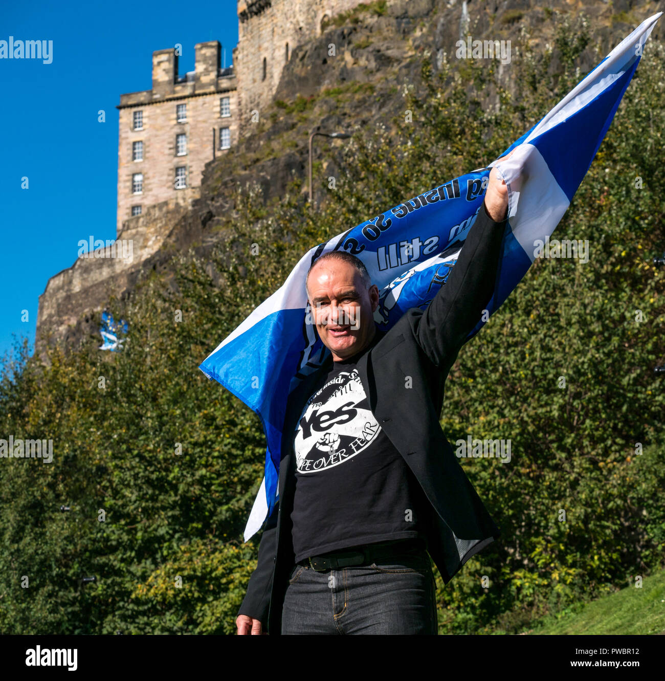 Tommy Sheridan, Scottish Independence supporter waving yes saltire flag All Under One Banner AUOB march, Edinburgh Castle, Scotland, UK Stock Photo
