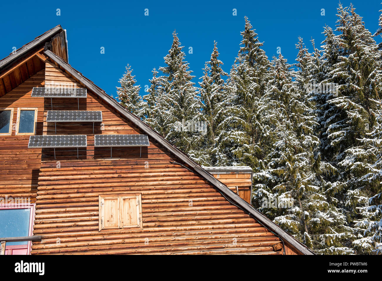 Solar Panel On A Wooden Lodge In The Forest At Winter Stock Photo