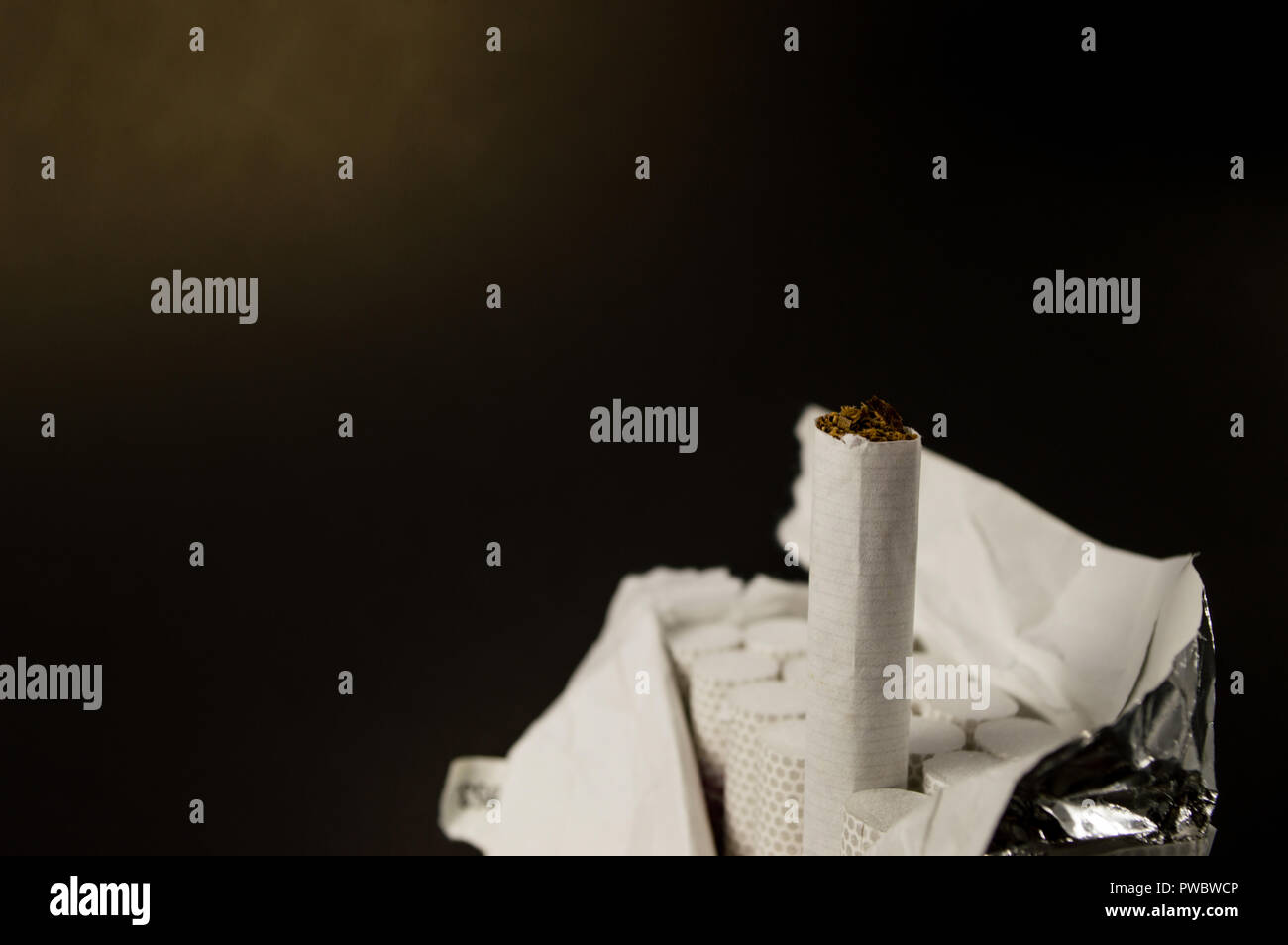 TOBACCO and CIGARETTE. A pack of cigarettes on black background, close-up of a cigarette Stock Photo