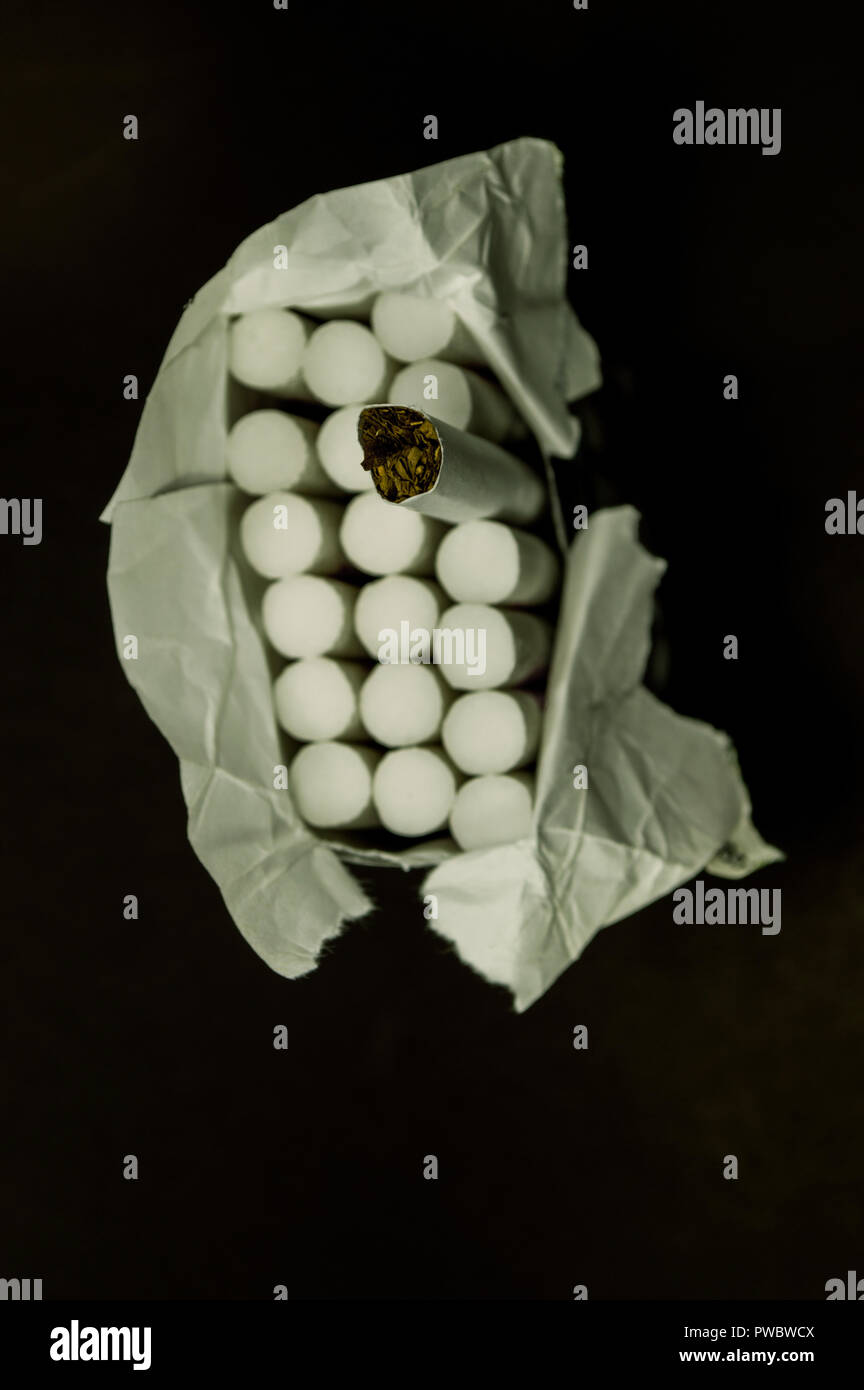TOBACCO and CIGARETTE. A pack of cigarettes on black background, close