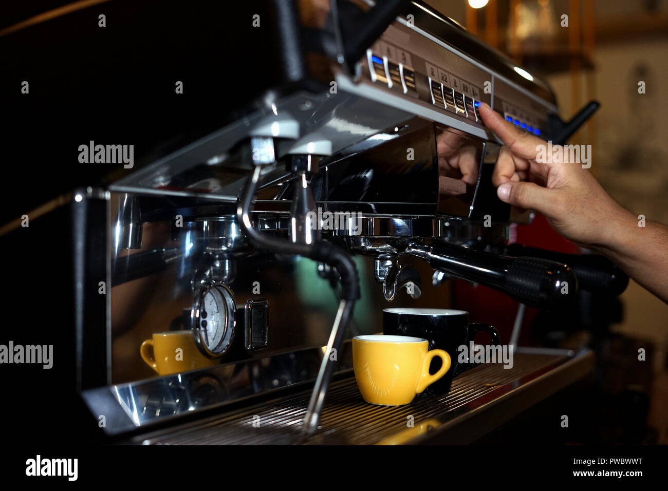 Barista making coffee using a coffee maker Stock Photo Alamy