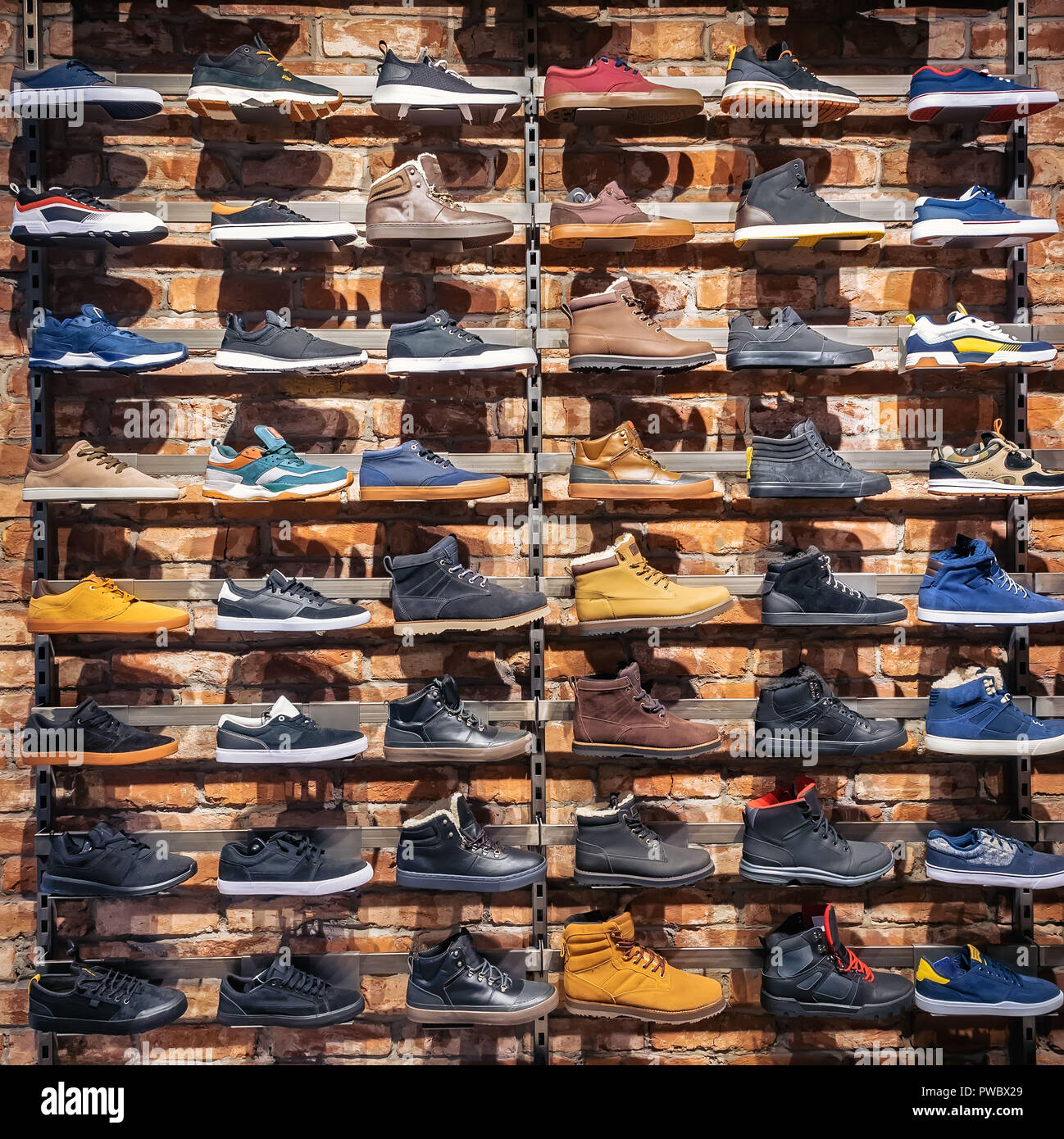 Lots of different shoes sneakers, boots, plimsolls on the showcase in