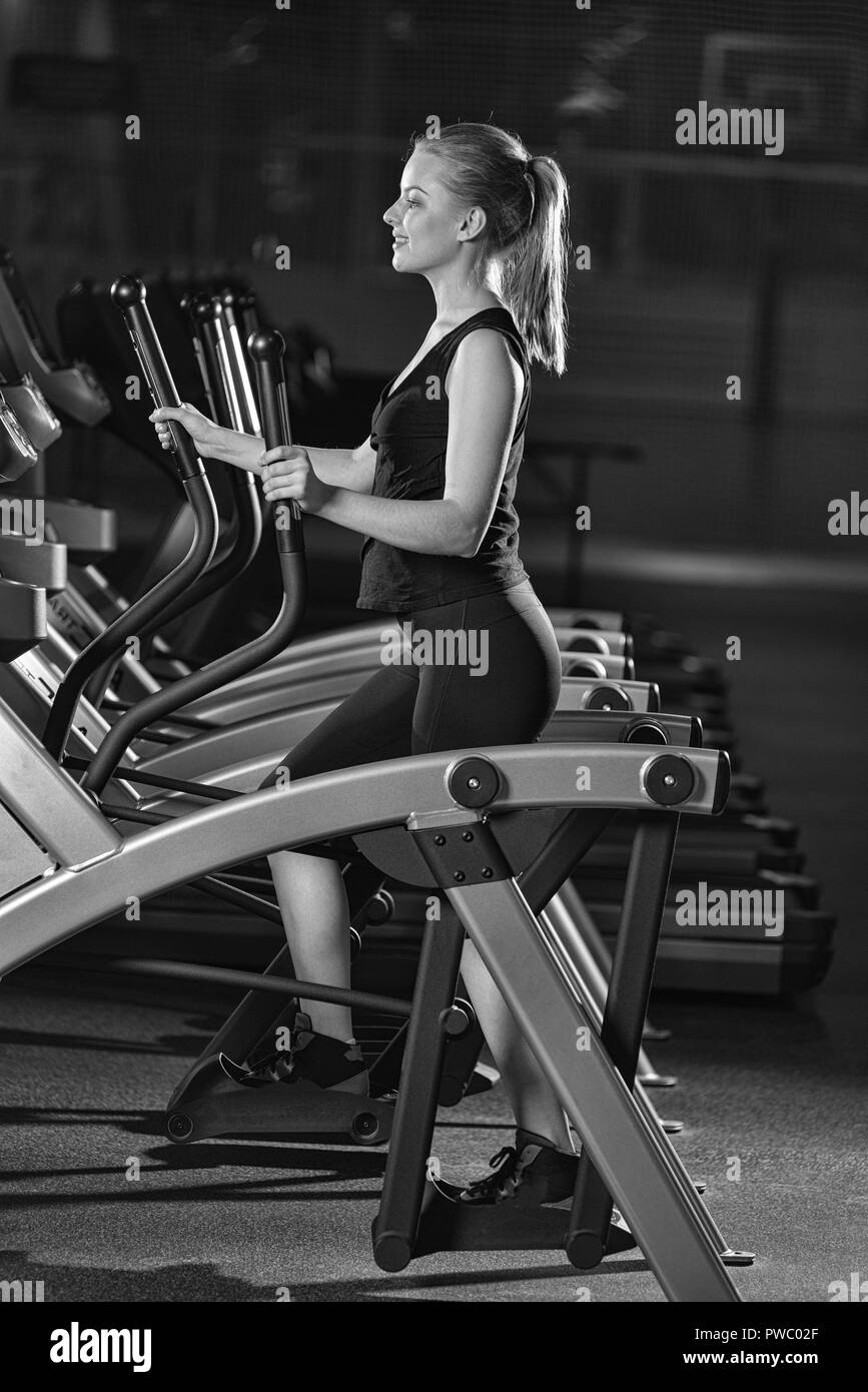 Young woman at the gym exercising. Run on machine. Stock Photo