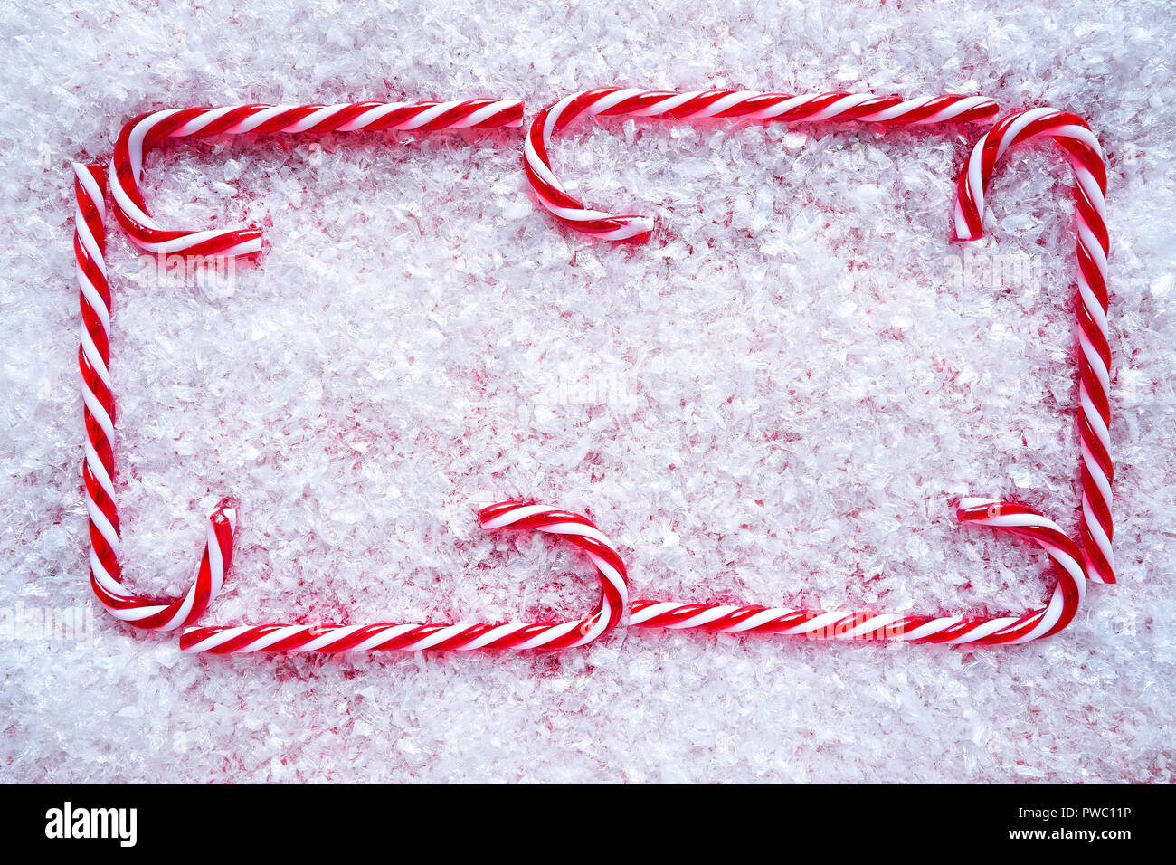 Christmas candy cane frame border on snow background Stock Photo - Alamy