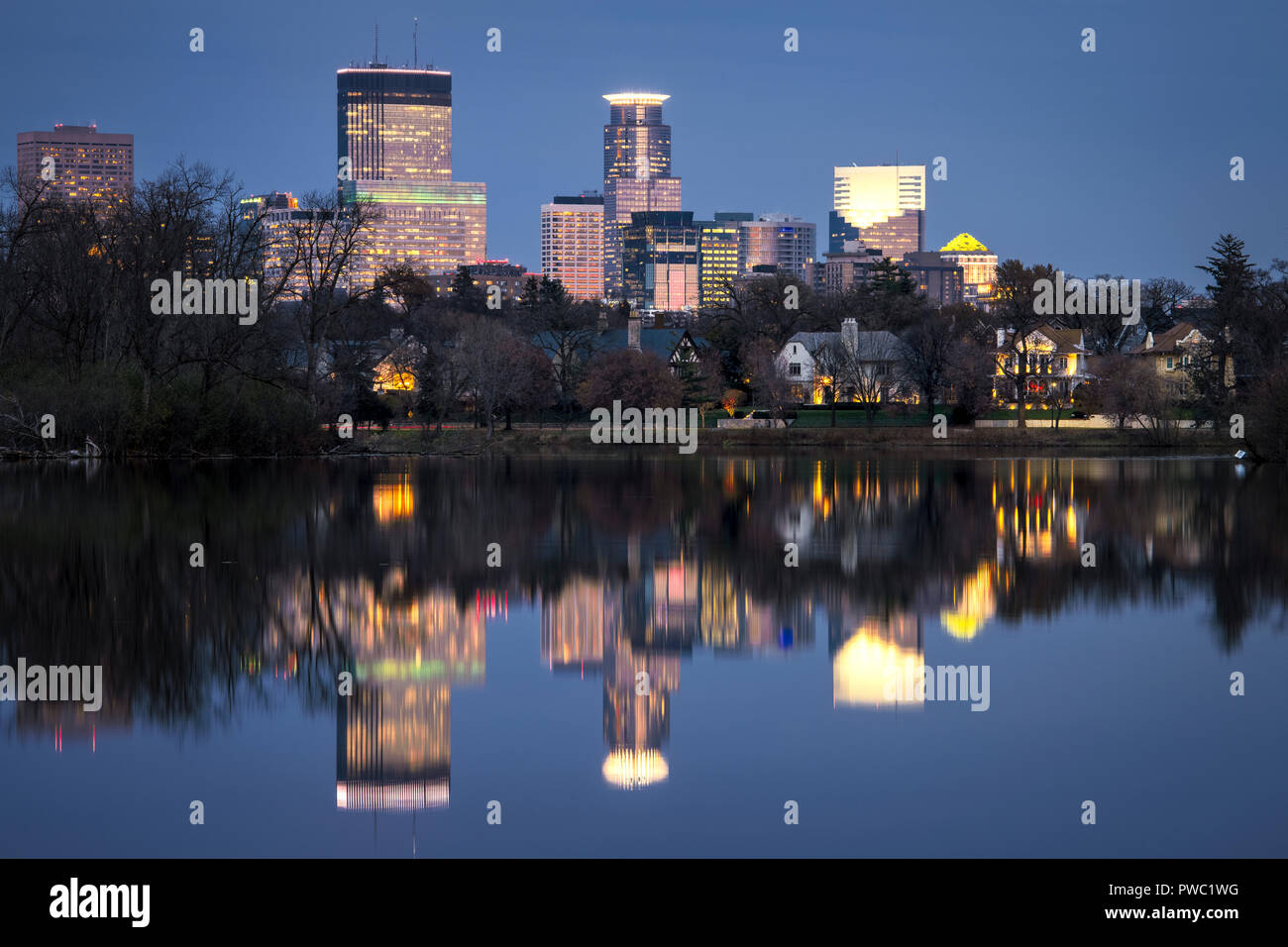 Minneapolis skyline reflected in the calm water of Lake of the Isles in late fall. Stock Photo