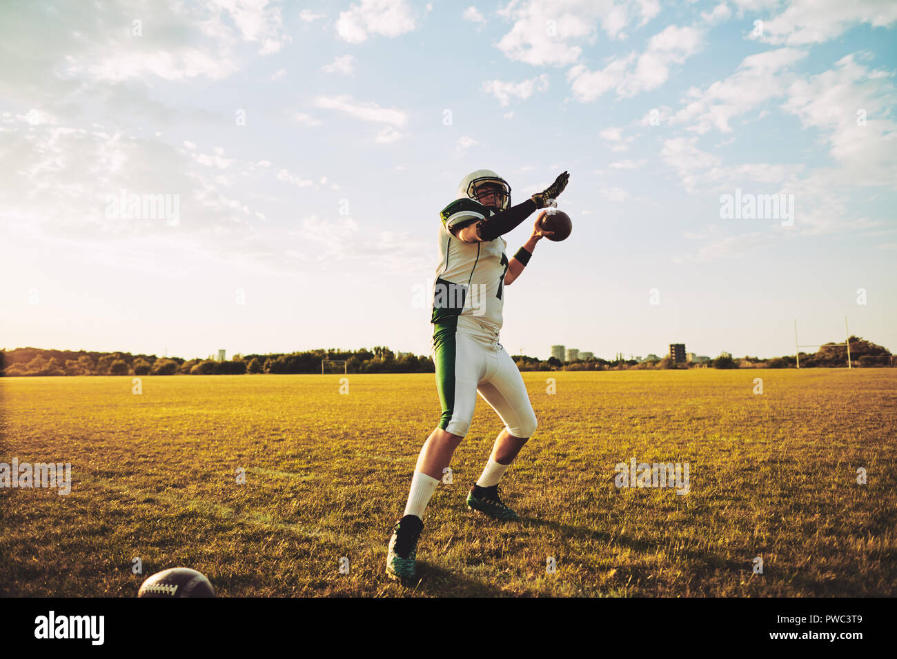 American football quarterback about to throw a football during team practice drills on a sports field in the afternoon Stock Photo