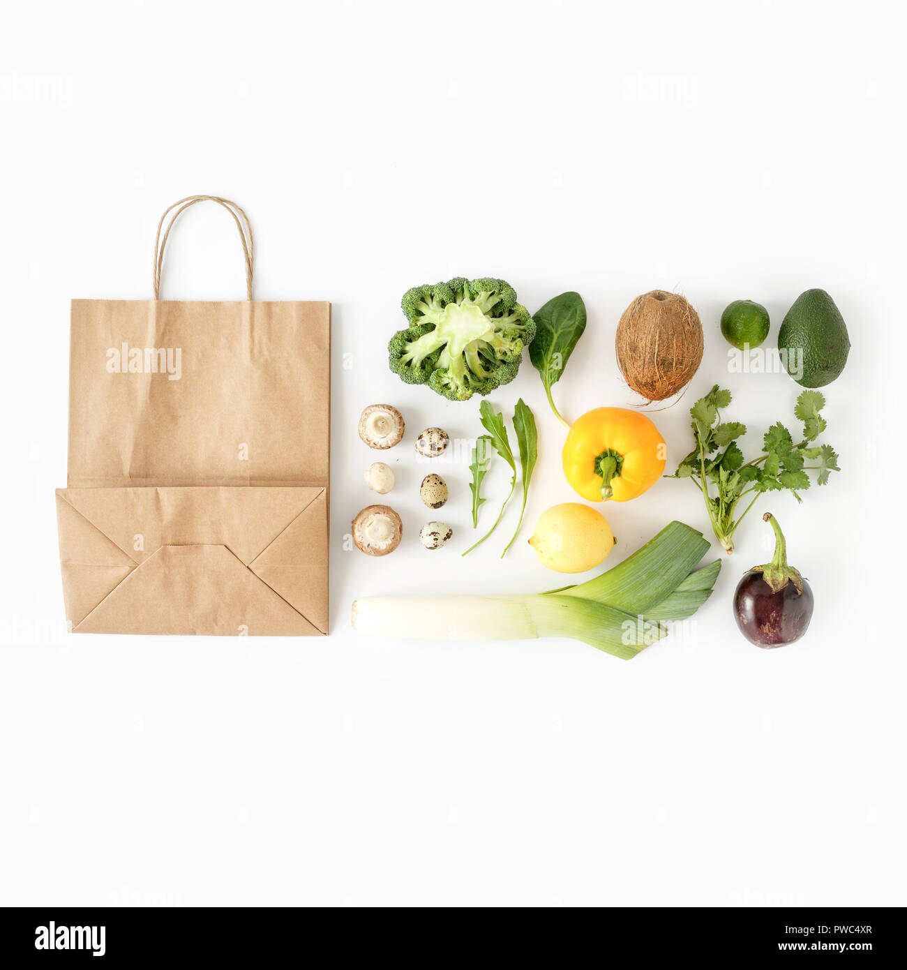 Healthy eating background, top view. Full paper bag of different health food on white background. Top view. Flat lay Stock Photo