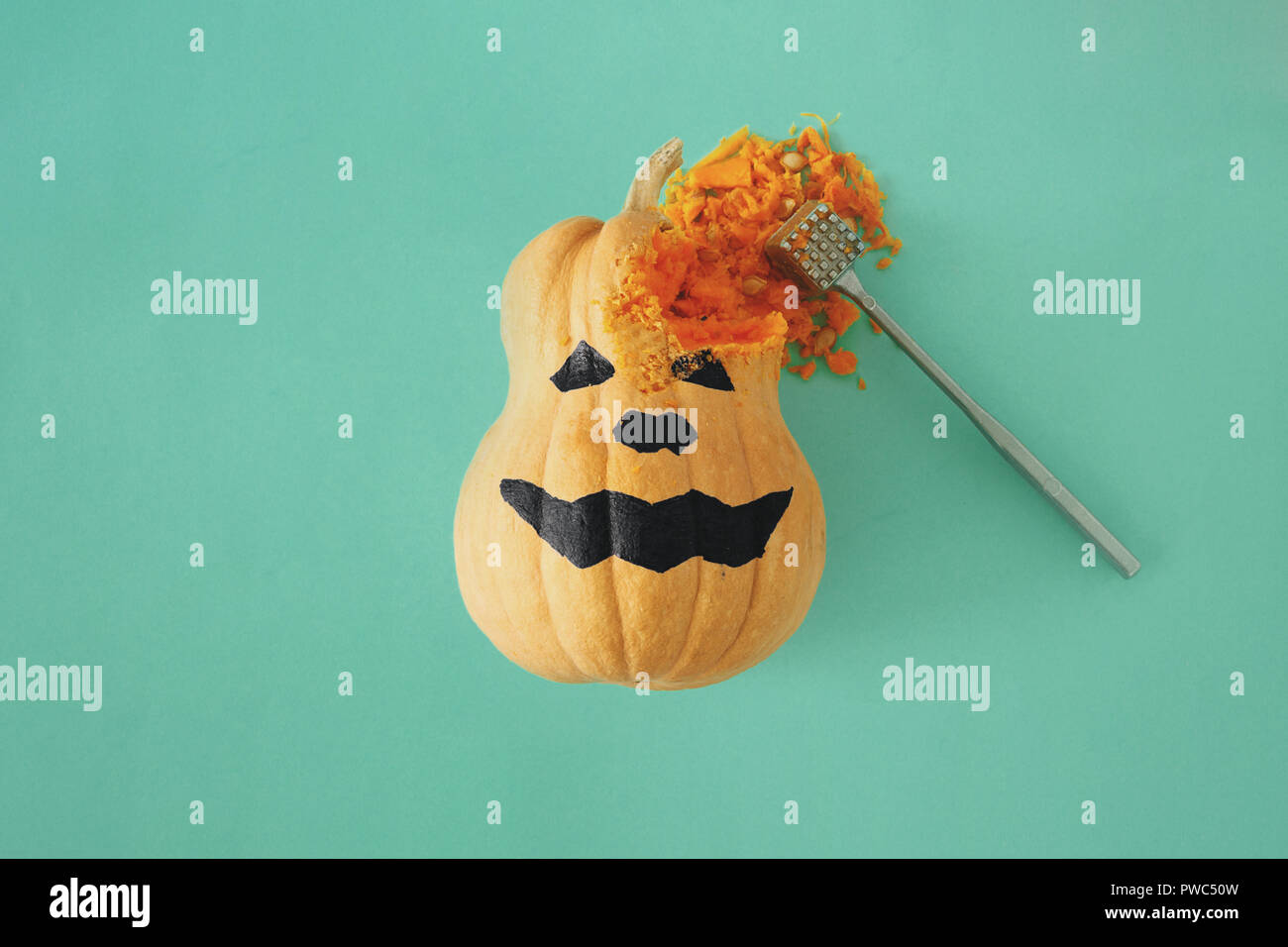 Flat lay funny scary face Halloween pumpkins on turquoise background. Fall autumn halloween minimal concept top view Stock Photo