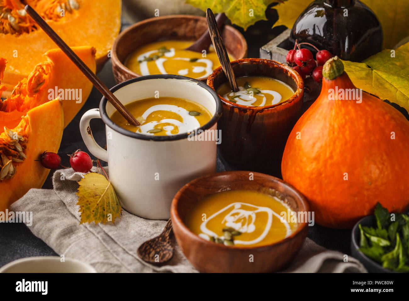 Autumn pumpkin soup puree with cream in cups, the autumn scenery. Healthy vegan food concept. Autumn food concept. Stock Photo