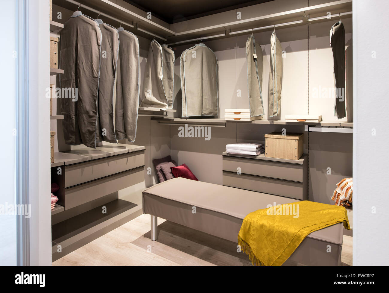 Interior Of A Walk In Closet With Hanging Clothes And Built In