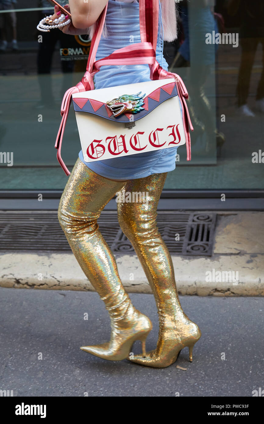MILAN, ITALY - SEPTEMBER 20, 2018: Woman walking with golden glitter high heel boots and Gucci bag with dragon before Vivetta fashion show, Milan Stock - Alamy