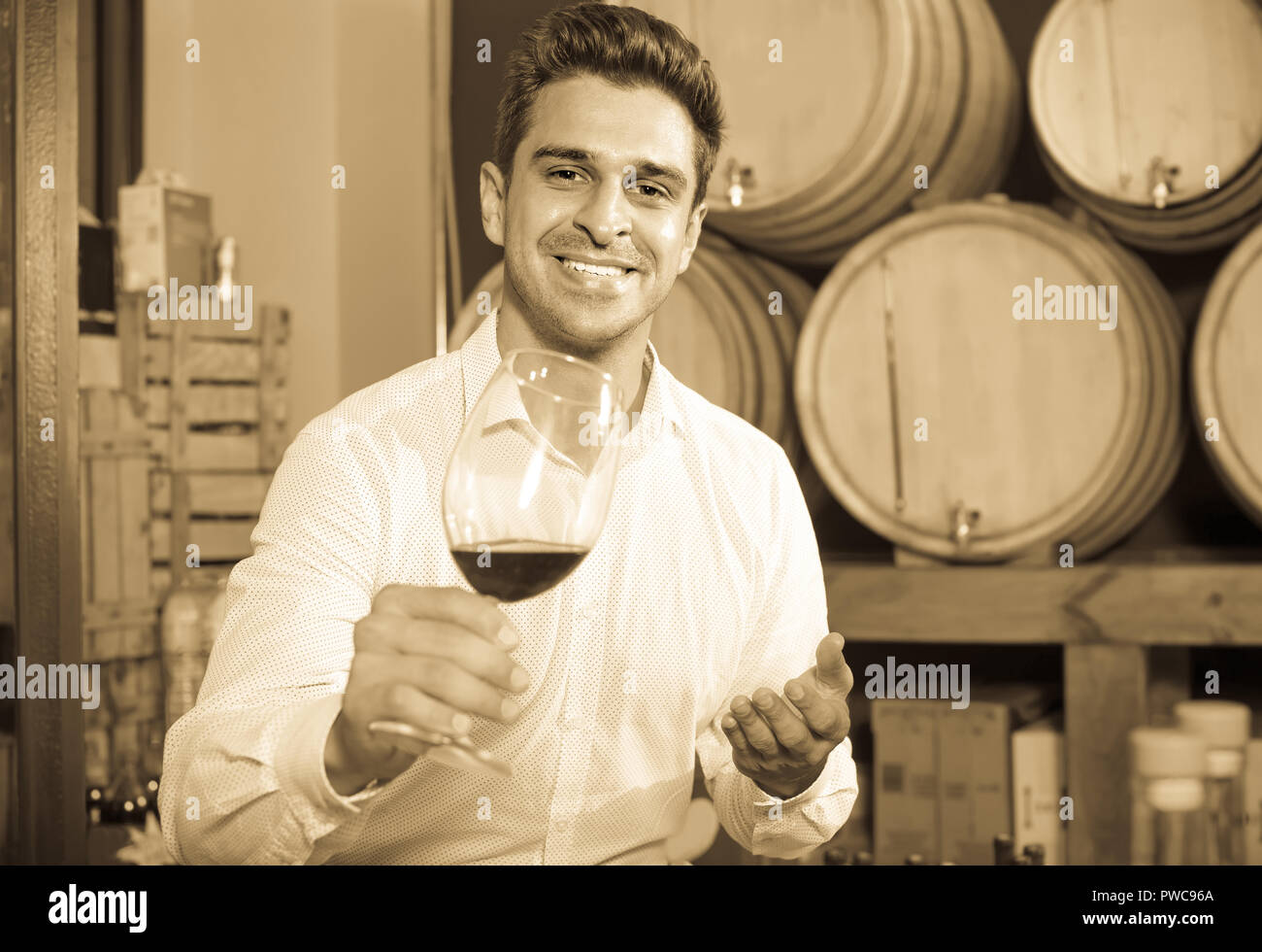 positive man having wine tasting in cellar with woods Stock Photo - Alamy