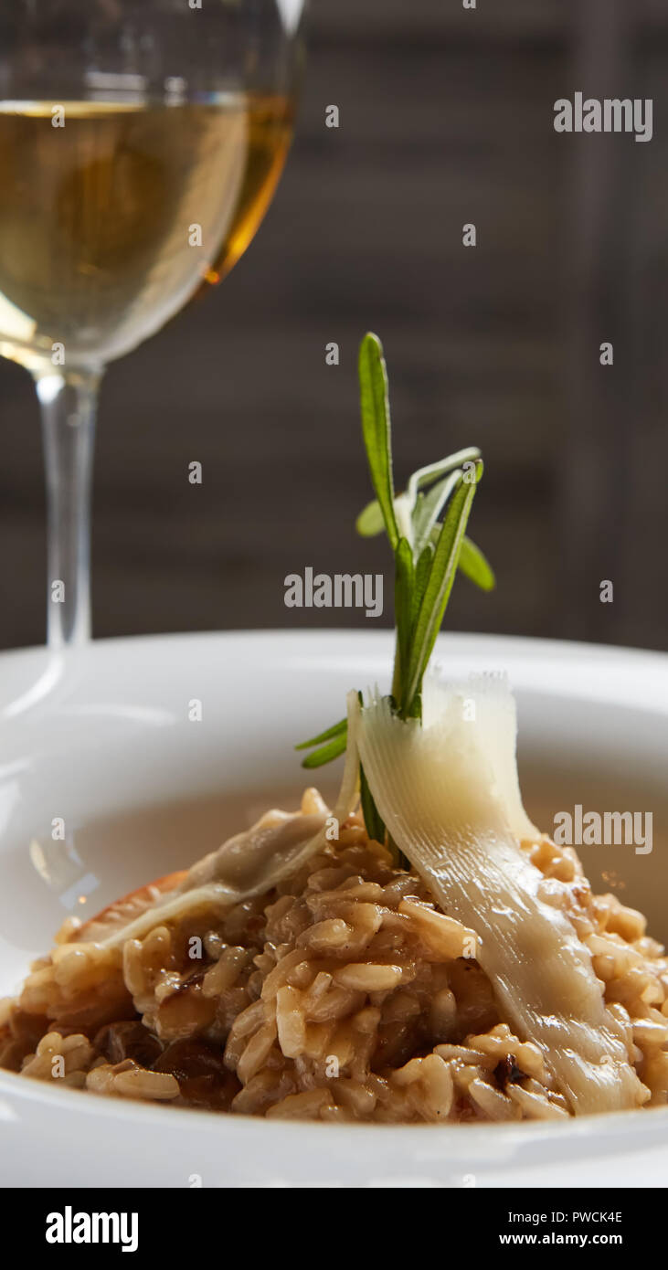 Italian dish risotto with wild white mushrooms and Parmesan cheese in a white plate. Stock Photo
