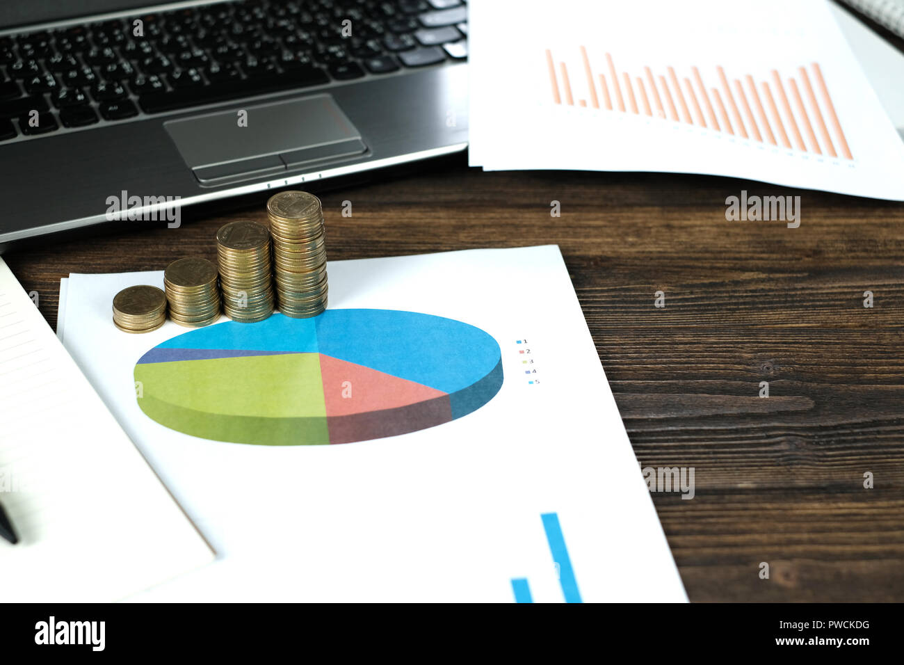 Step of coins stacks with notebook laptop computer and financial graph ...