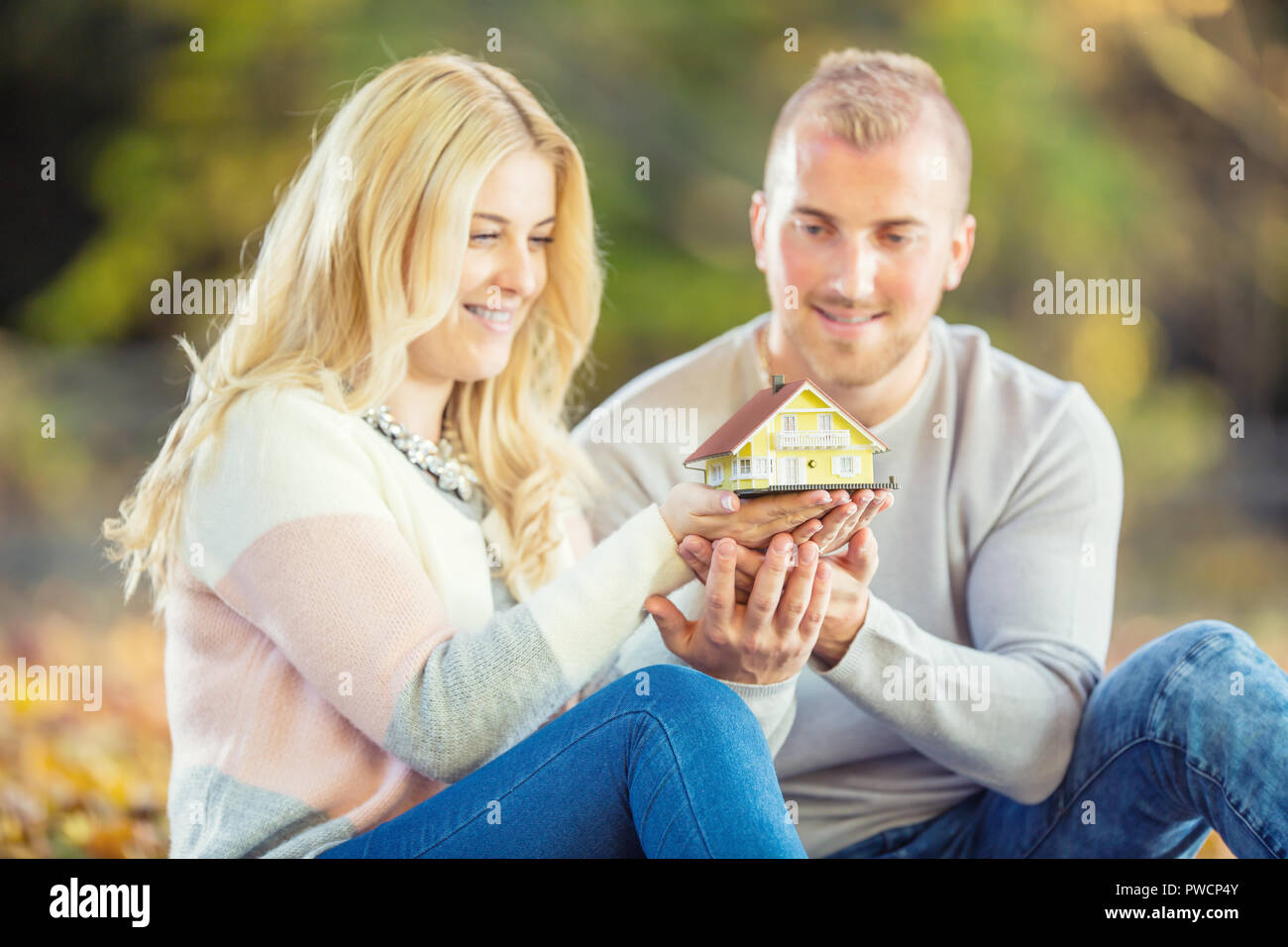 Young loving couple holding small model house Stock Photo - Alamy