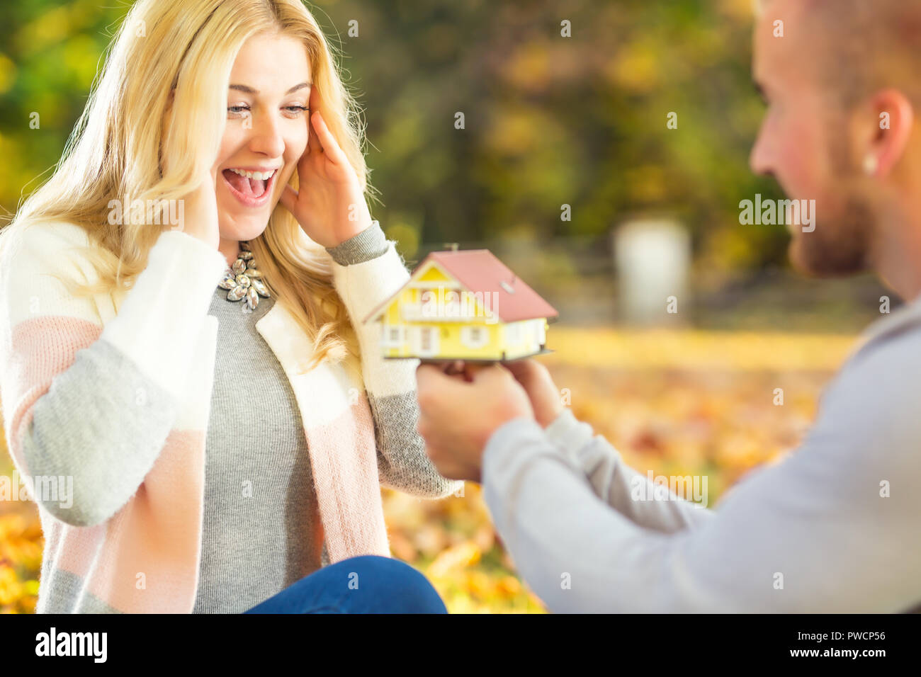 Young marriage couple husband surprises wife spouse with new family