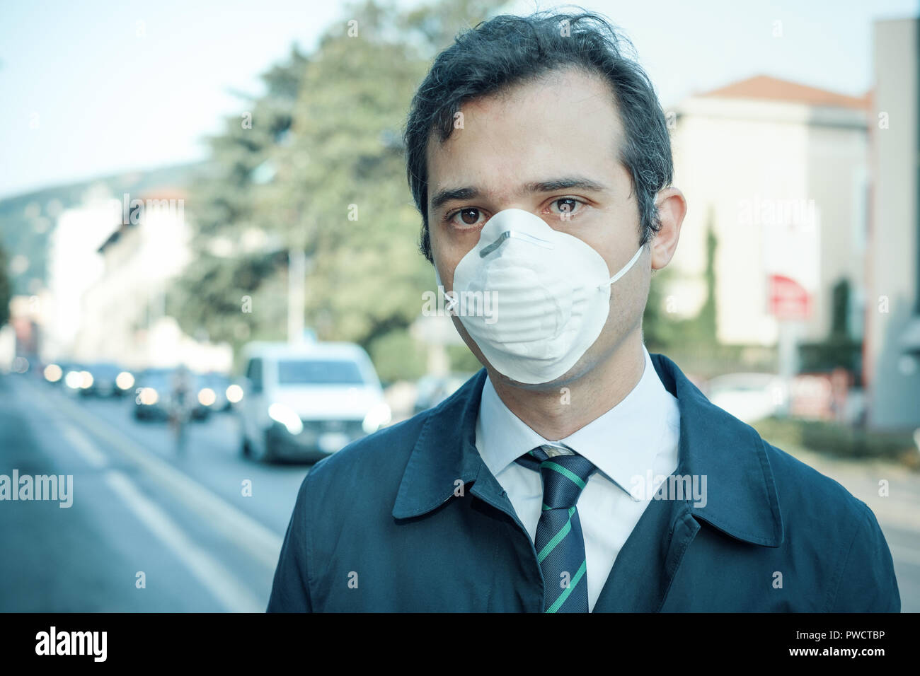Man wearing mask against smog air pollution Stock Photo