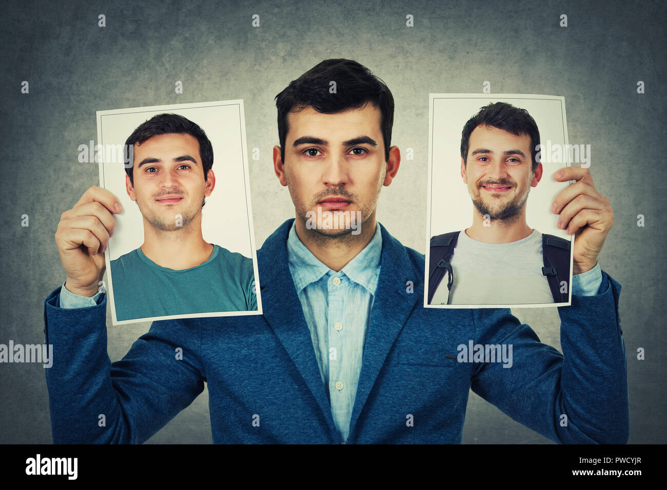 Young man holding two portrait photo sheets with different character. Change your personality, fake mask to hide the real expression of yourself. Stock Photo