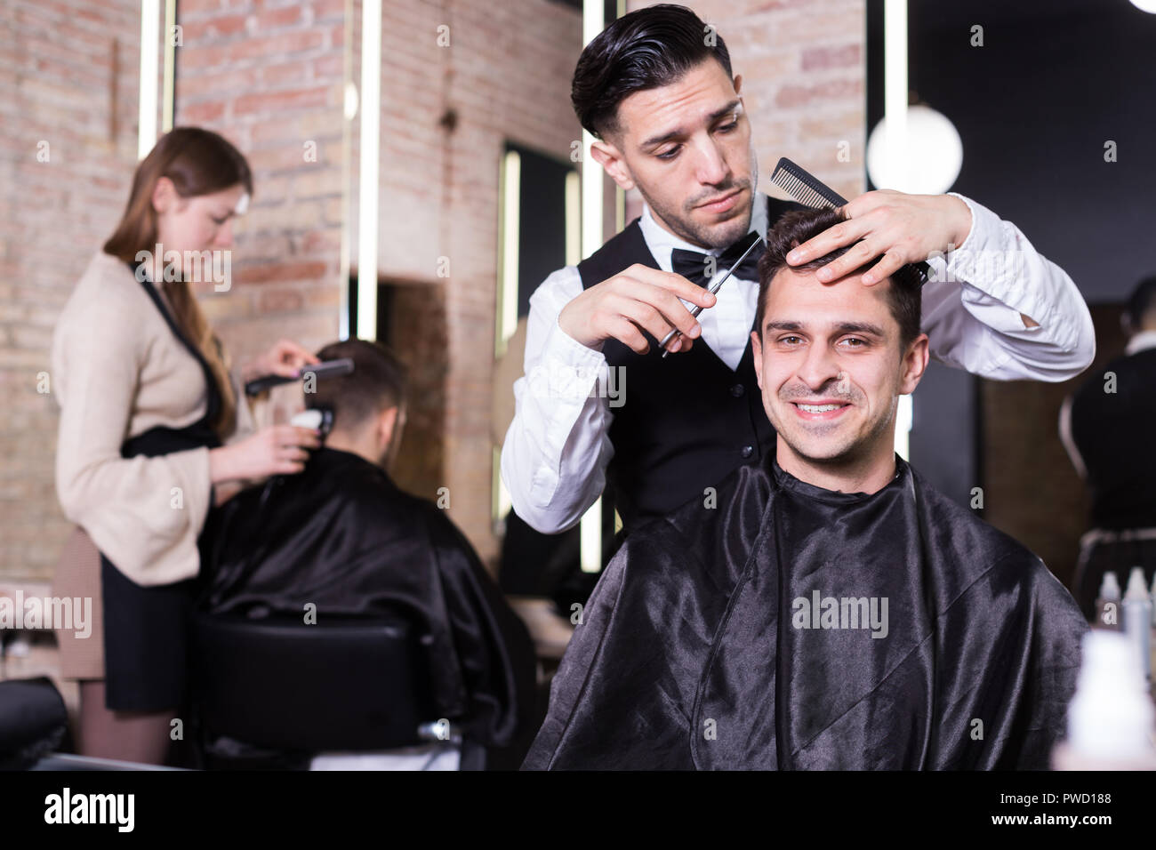 Professional Hairdresser Man Doing Styling Of Handsome Guy At