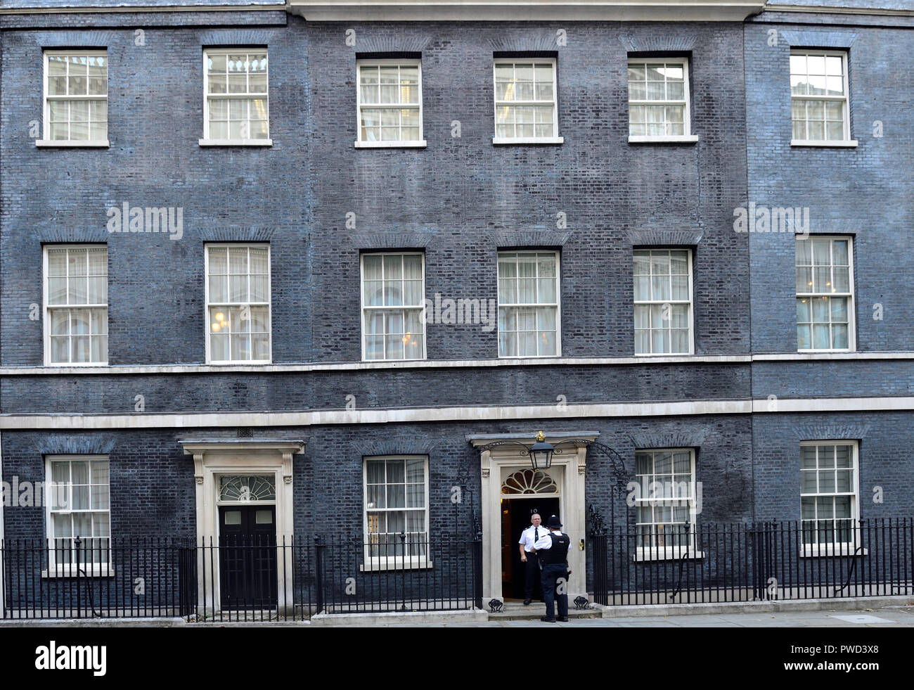 Police officers talking in the doorway of No 10 Downing Street, London, England, UK. Stock Photo