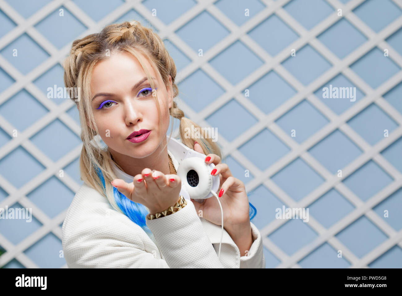 Sends a kiss. Enjoy the music. Girl with colored hair and big headphones. Listening music Stock Photo