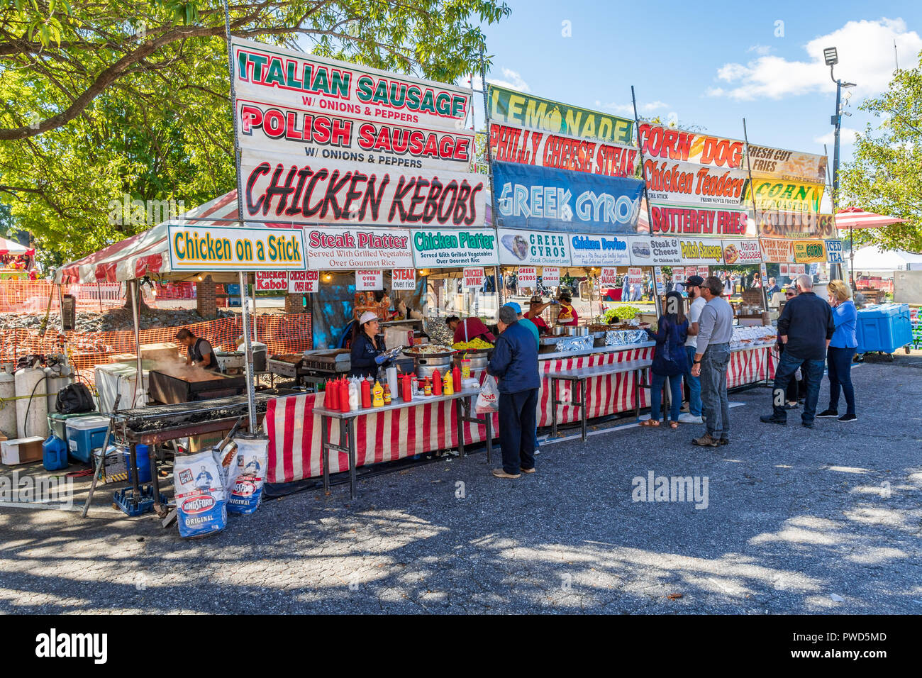 HICKORY, NC, USA-10/14/18: A concession stand at a local fall festival offers Itialian sausage and chicken kebobs.  Customers stand in line. Stock Photo