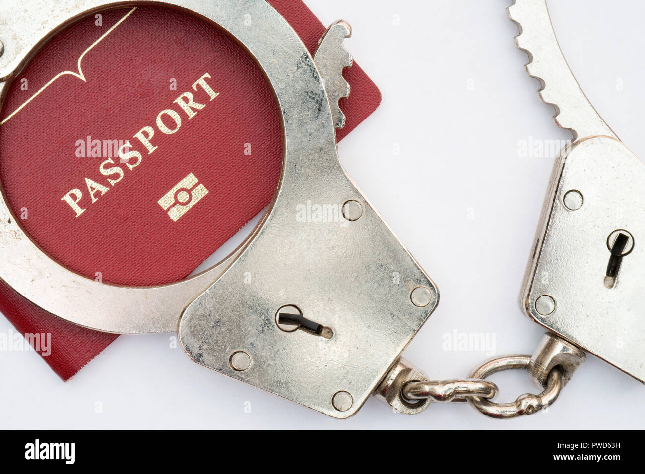 red passport on white background and handcuffs Stock Photo