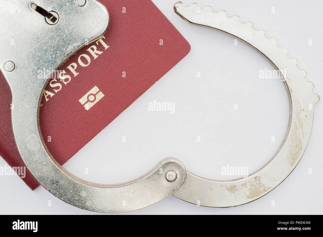 red passport on white background and handcuffs Stock Photo