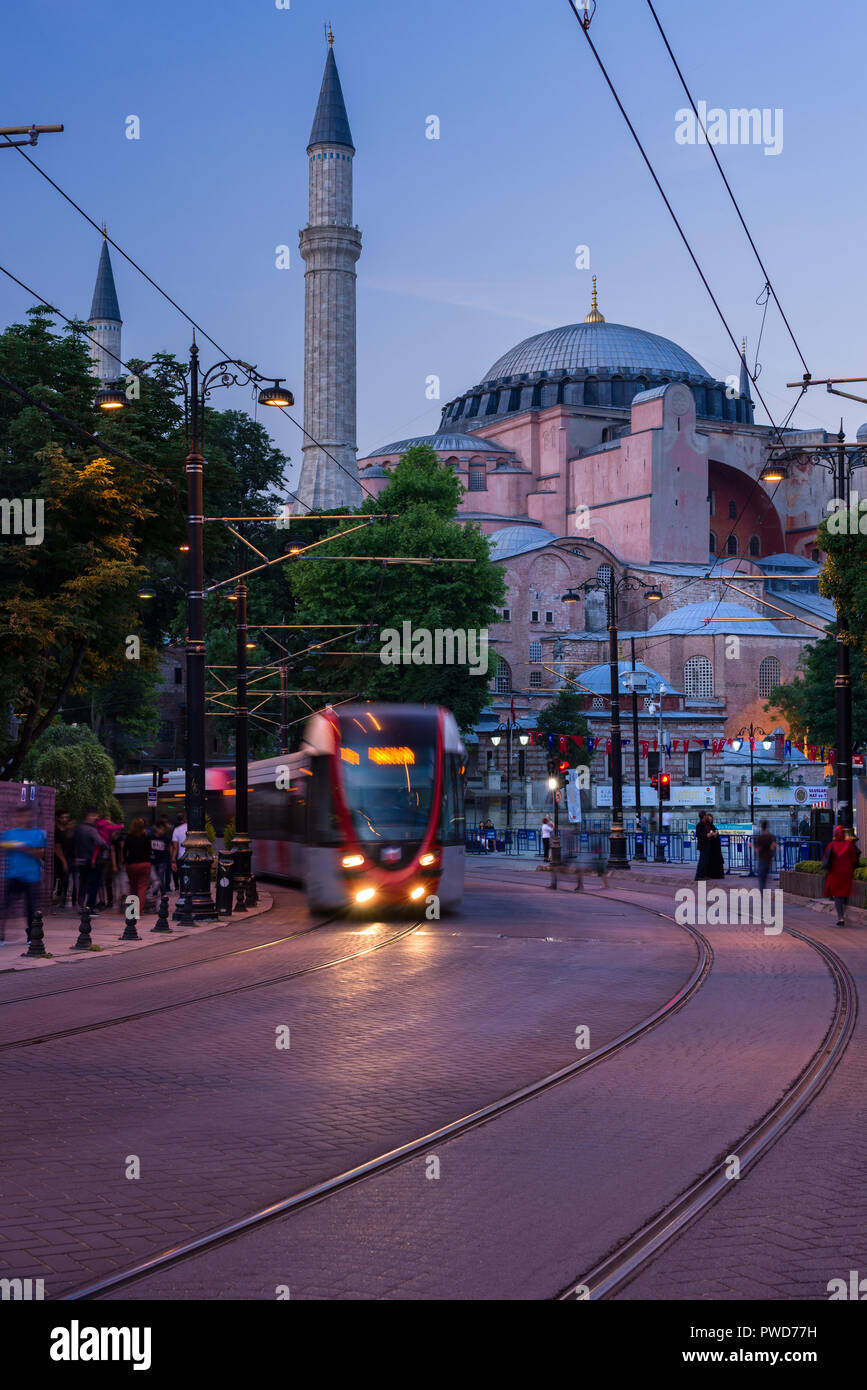 A T1 tram passes the Hagia Sophia museum at dusk, Istanbul, Turkey Stock Photo