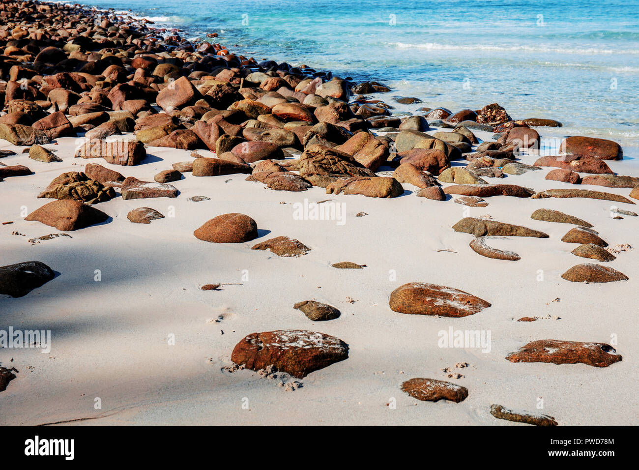Rocks on sand with sunlight at the sea Stock Photo - Alamy