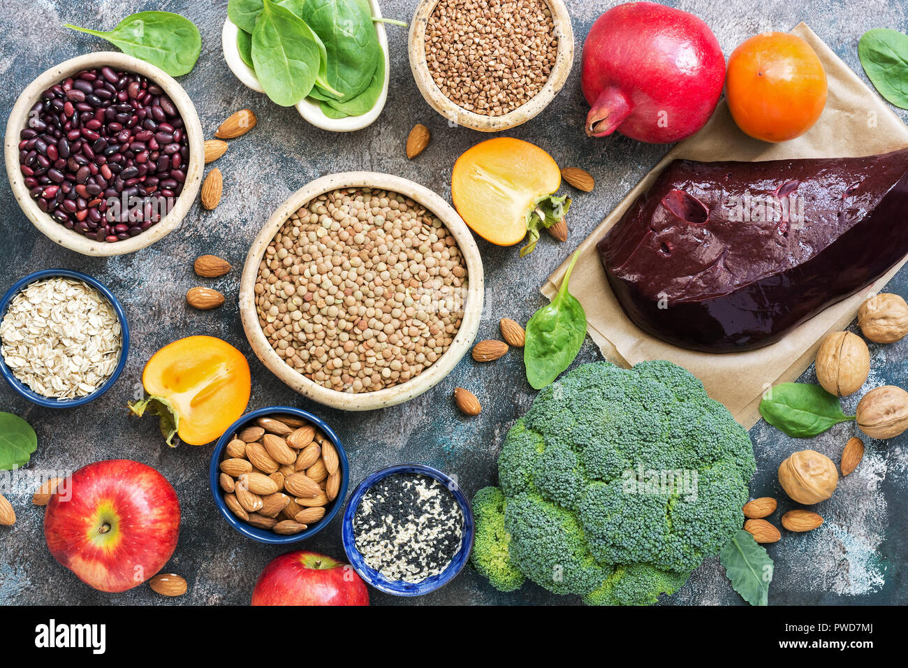 Foods high in iron. liver, broccoli, persimmon, apples, nuts, legumes, spinach, pomegranate. Top view, flat lay Stock Photo