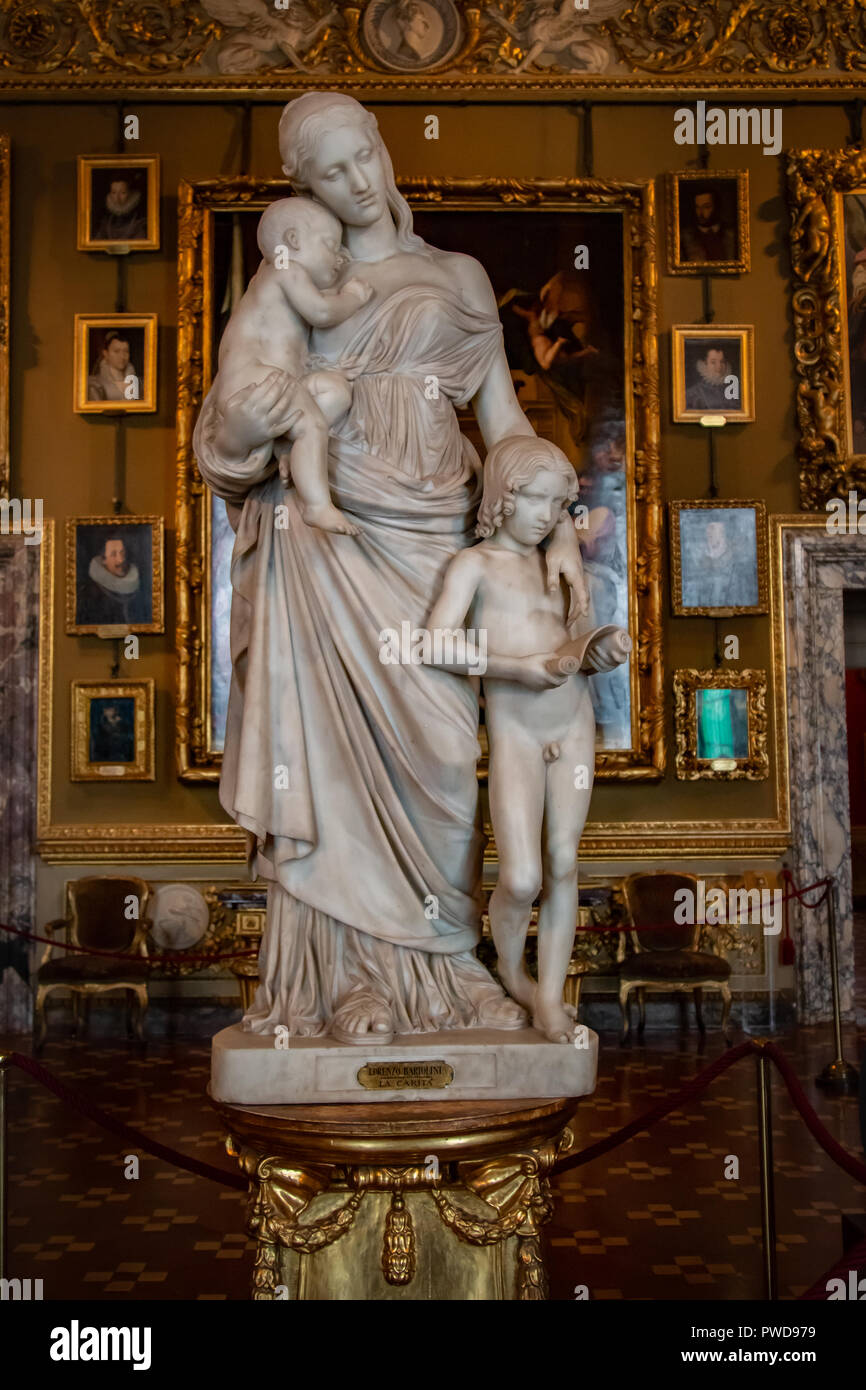 A marble statue titled Charity depicts a woman carrying a baby when a