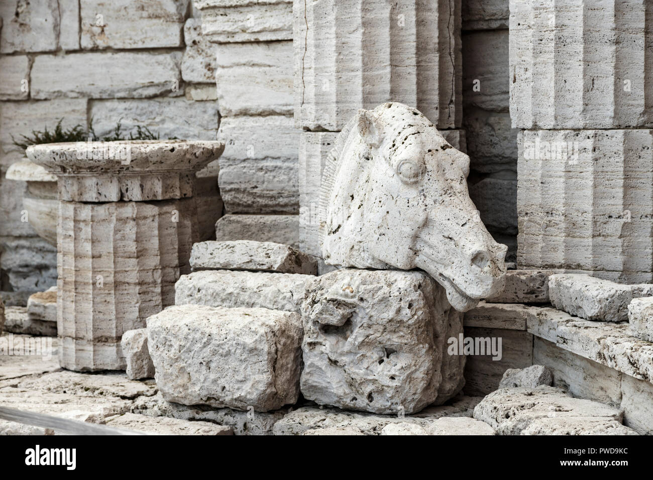 greek ruins closeup. ancient columns and the stone head of a horse