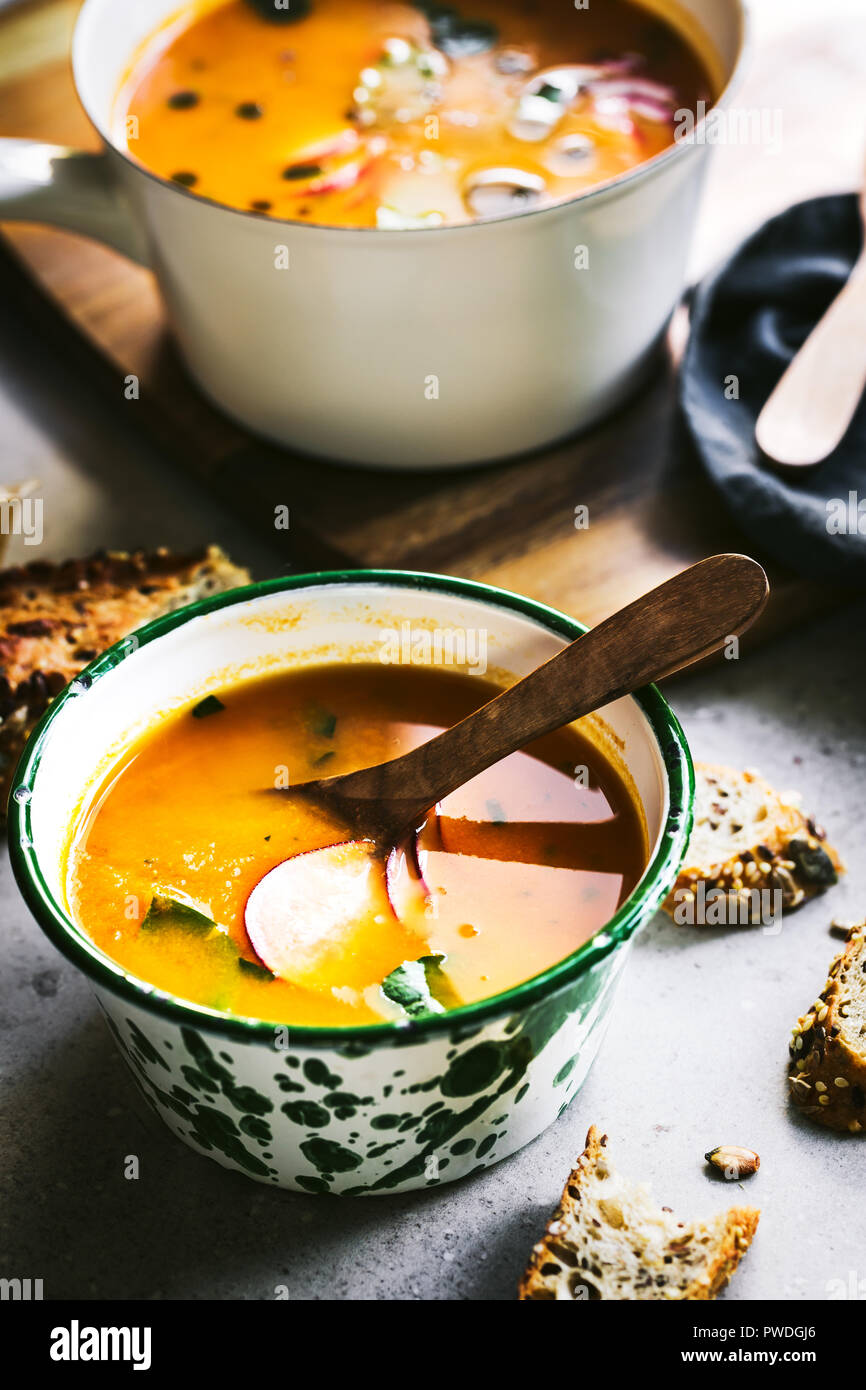 Carrot and Pumpkin soup with Basil oil by Multigrain seeds bread Stock Photo