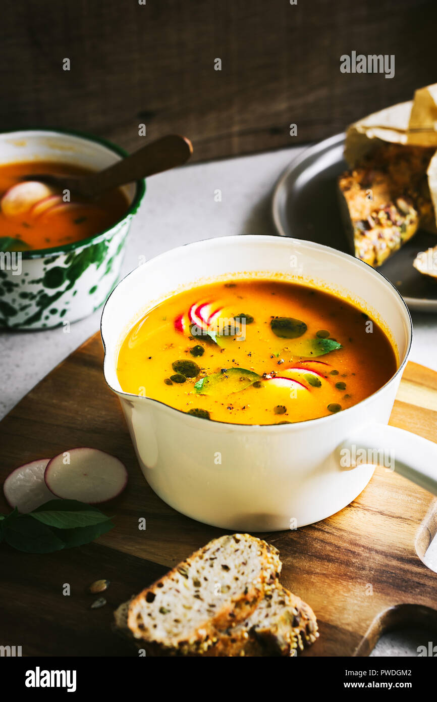 Carrot and Pumpkin soup with Basil oil by Multigrain seeds bread Stock Photo