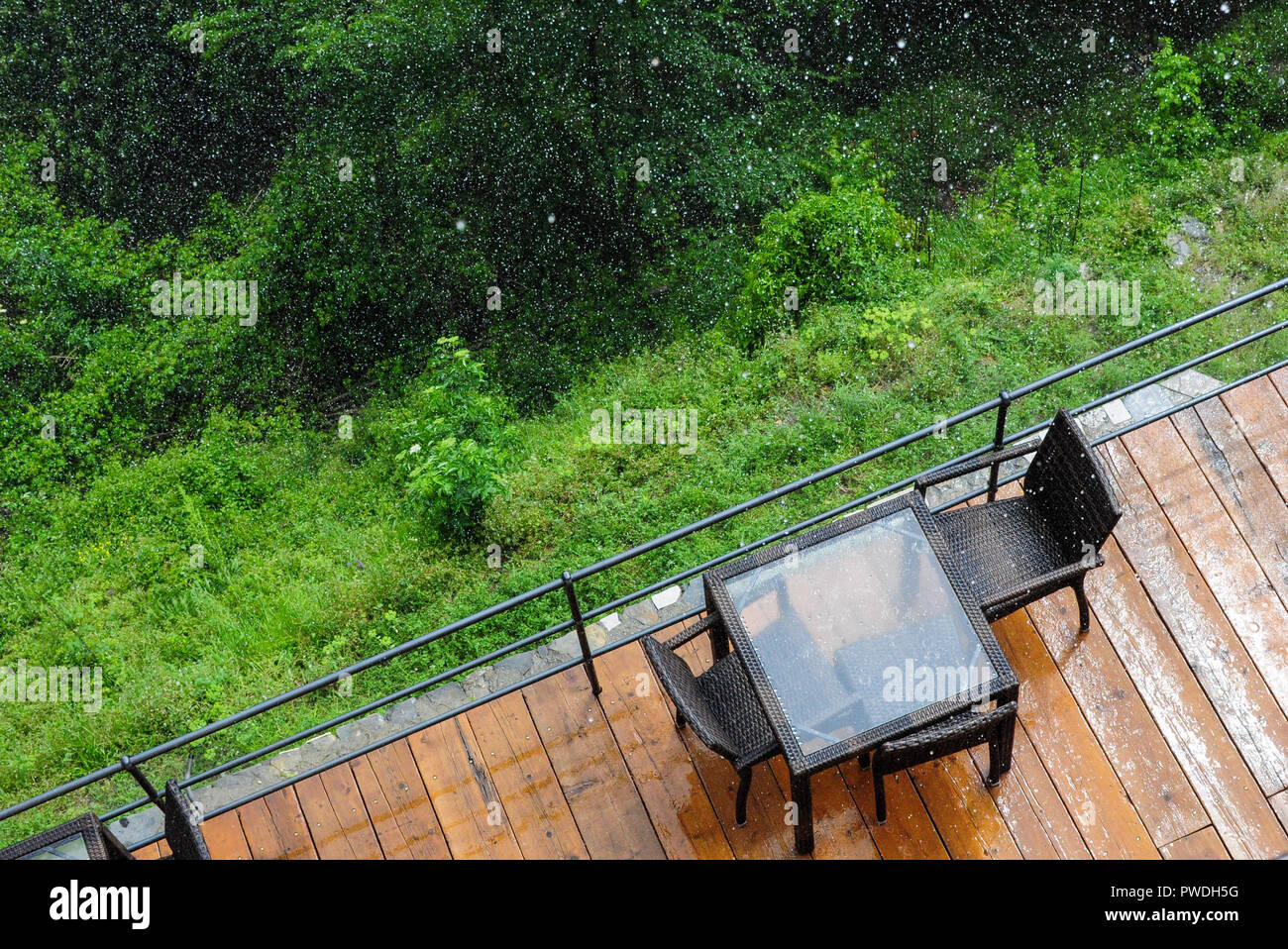 A top view of an outdoor table and chairs in the rain Stock Photo