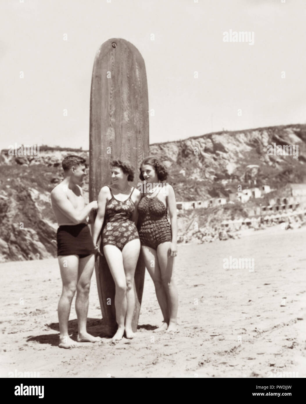 Flight Lieutenant H.G. Winders of Coolangatta, Queensland (left), who gave surfboard riding exhibitions at Newquay, Cornwall, with Miss Joy Nichols of London (center) and Mrs. Esme Sanderson, of London during a two day aquatic carnival by Royal Australian Air Force personnel on leave at an ACF leave hostel at Newquay in July 1945. Stock Photo
