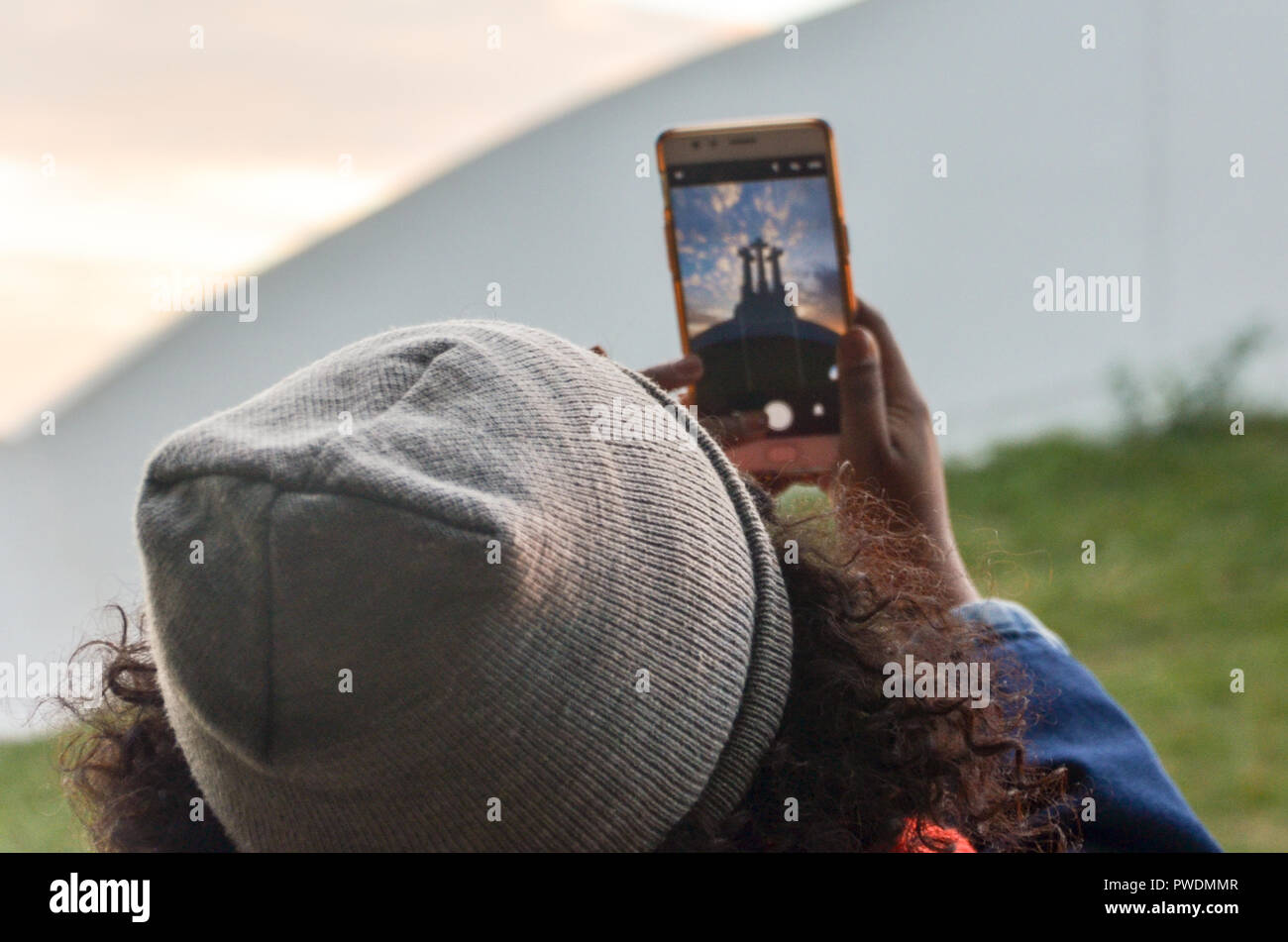 Woman with a hat taking a smartphone photo of the Three Crosses monument in Vilnius, Lithuania Stock Photo