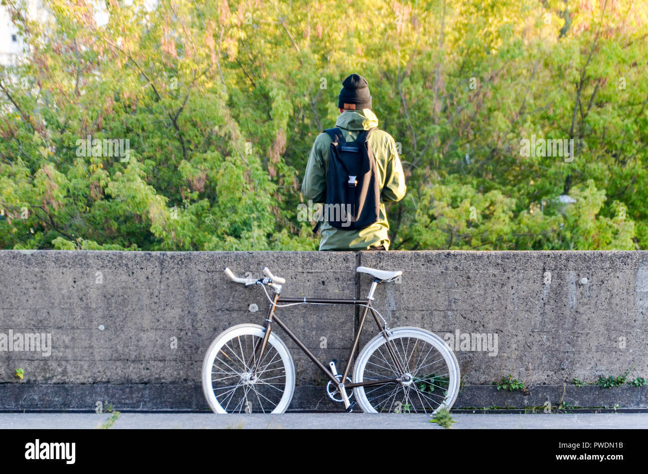 Man in Vilnius, Lithuania, with a fixed-gear bicycle, in fromt of Gediminas hill Stock Photo