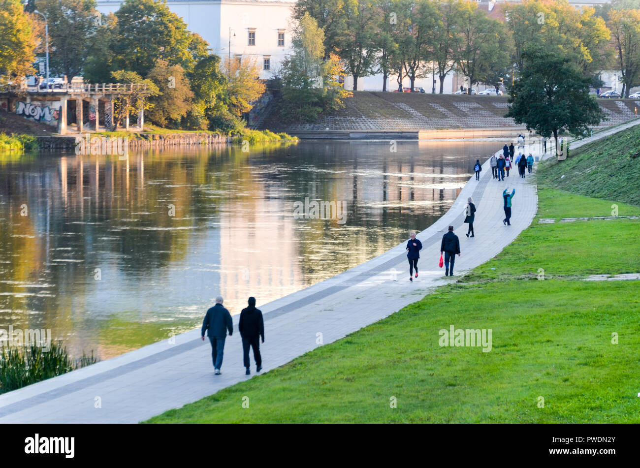 People walking on the promenade by the Neris River, Vilnius, Lithuania Stock Photo