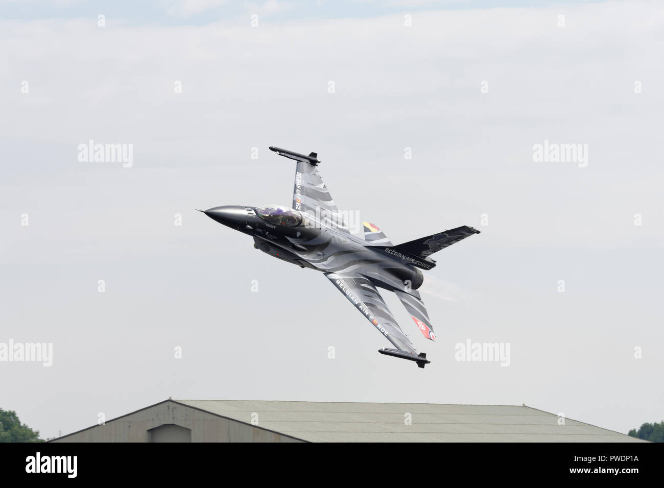 Lockheed Martin F-16 Fighting Falcon Combat Jet from the Belgian Air Force gives a wing waggle as it departs RAF Fairford Airbase after the RIAT Stock Photo